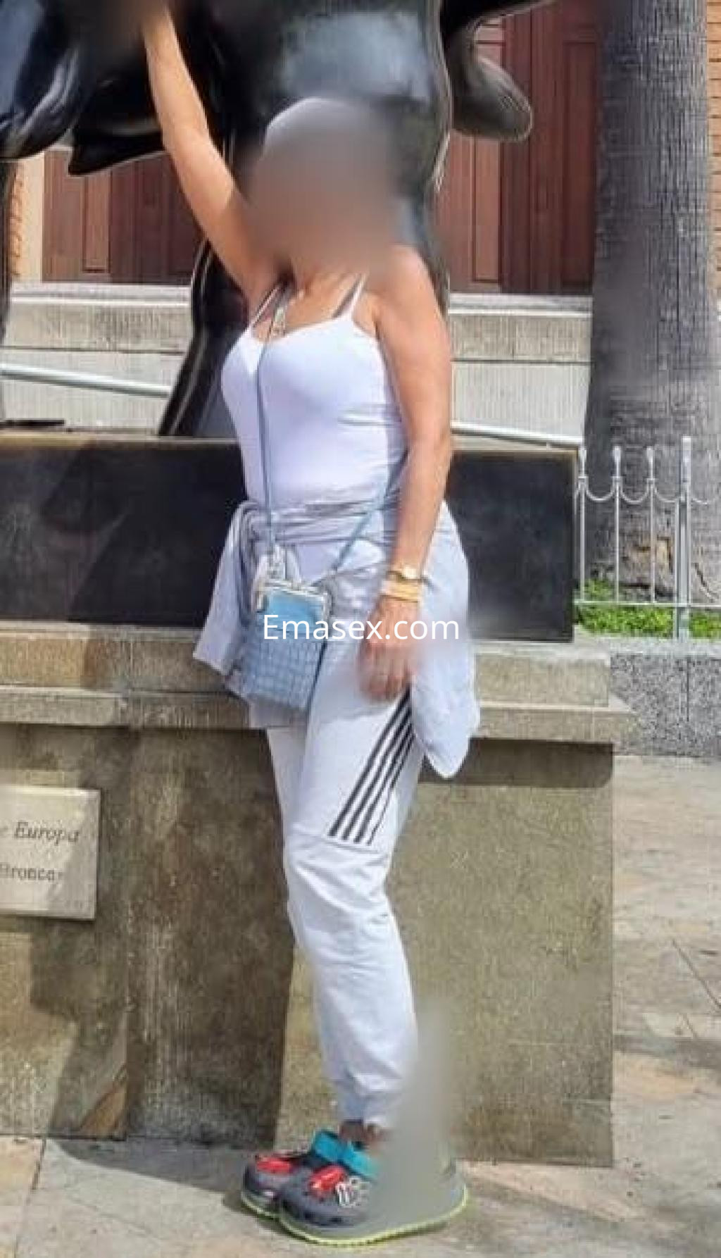 La puta viste una camiseta blanca sin mangas, pantalones deportivos grises y zapatillas en Badajoz.