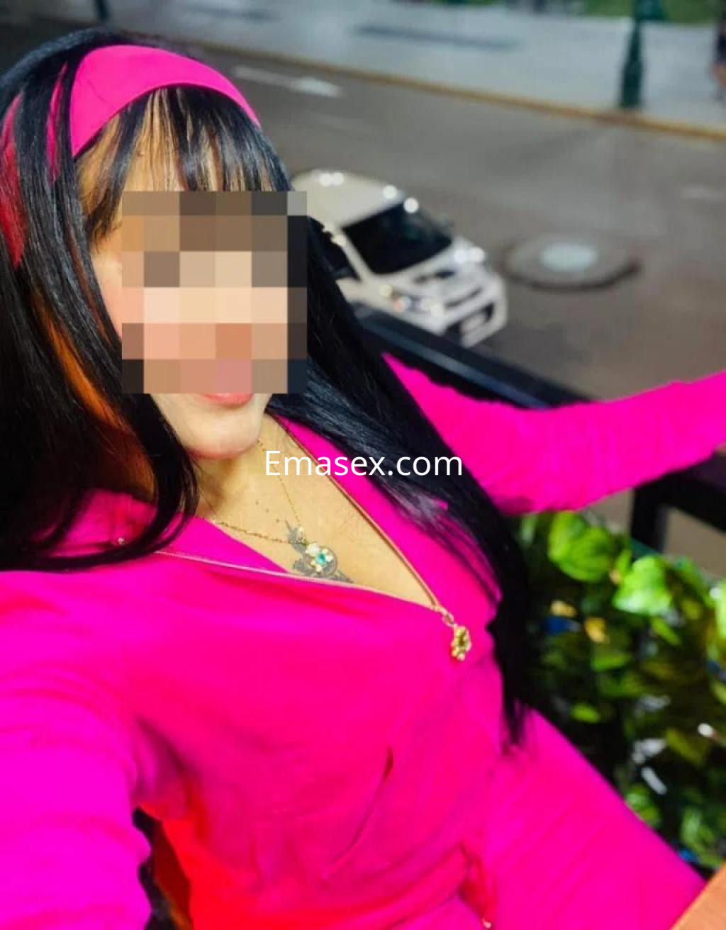 La puta viste un conjunto rosa brillante y posa con cabello largo y lacio en una terraza en Coruña.