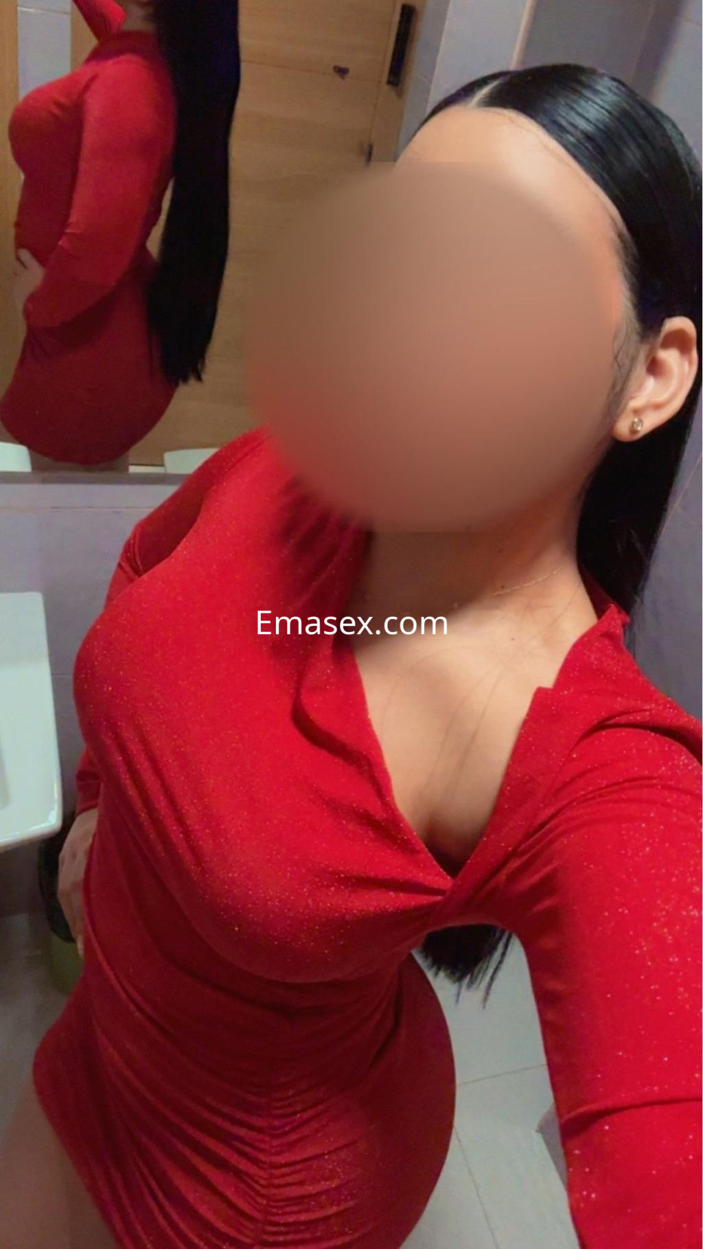 Escort en Vigo con vestido rojo ajustado, mostrando una pose elegante y un fondo minimalista.