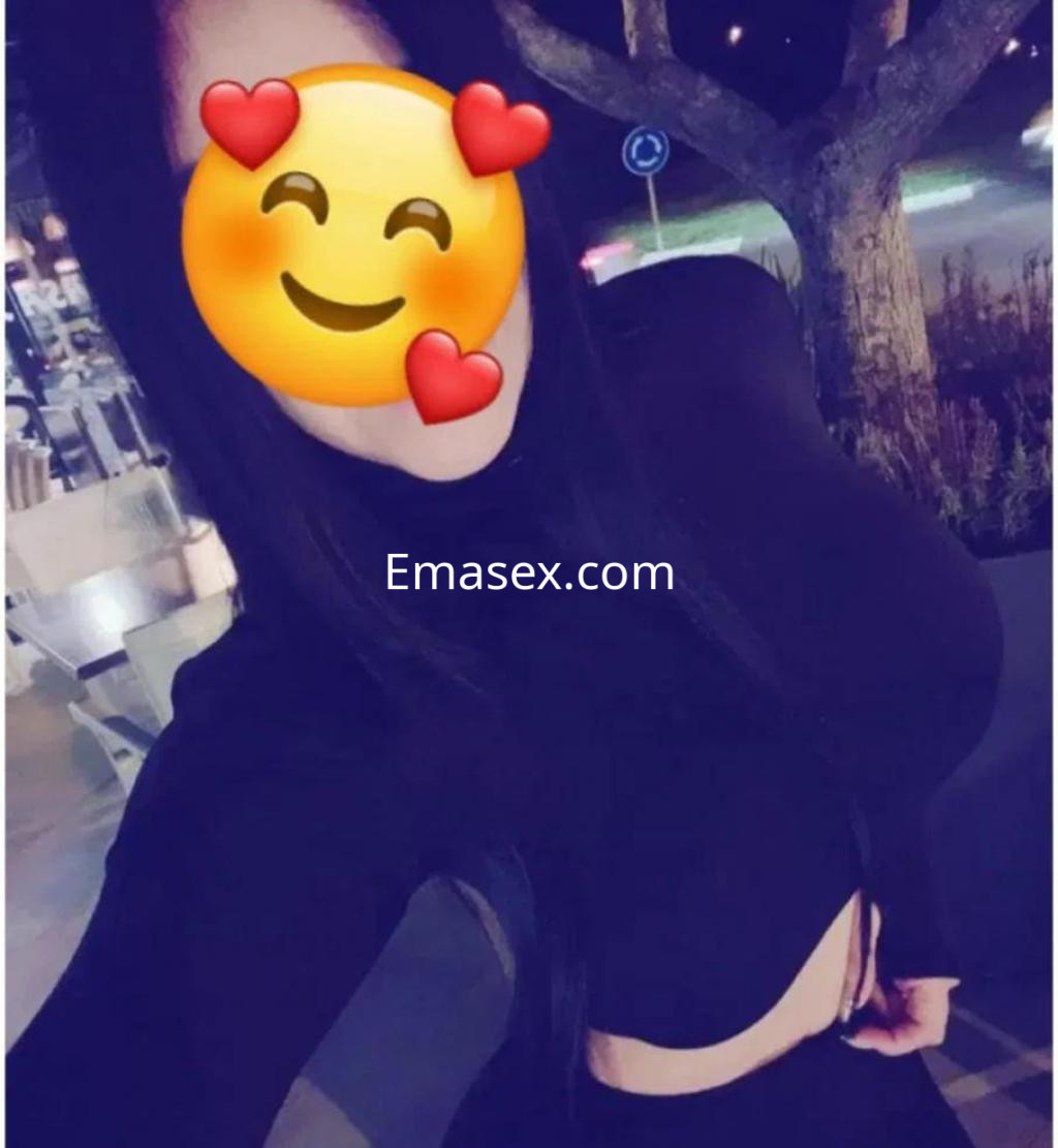 Escort en Badajoz con cabello largo y lacio, viste un top negro ajustado que destaca su figura.