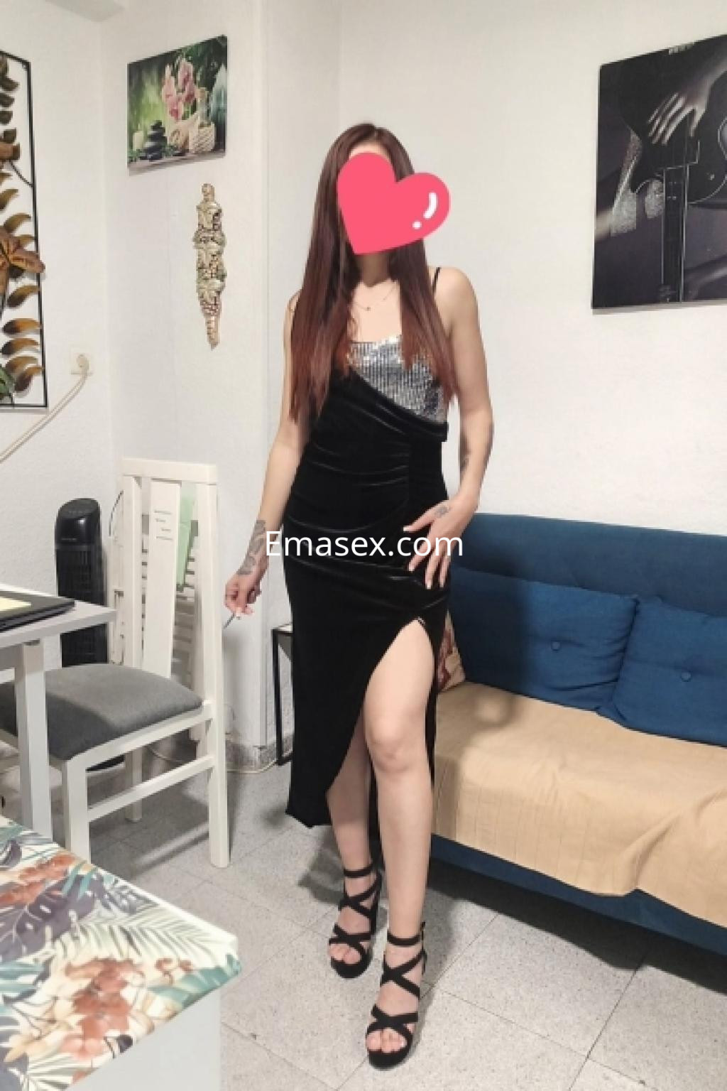 Escort en Almería con vestido negro ajustado y escote, posando con una pierna ligeramente levantada.