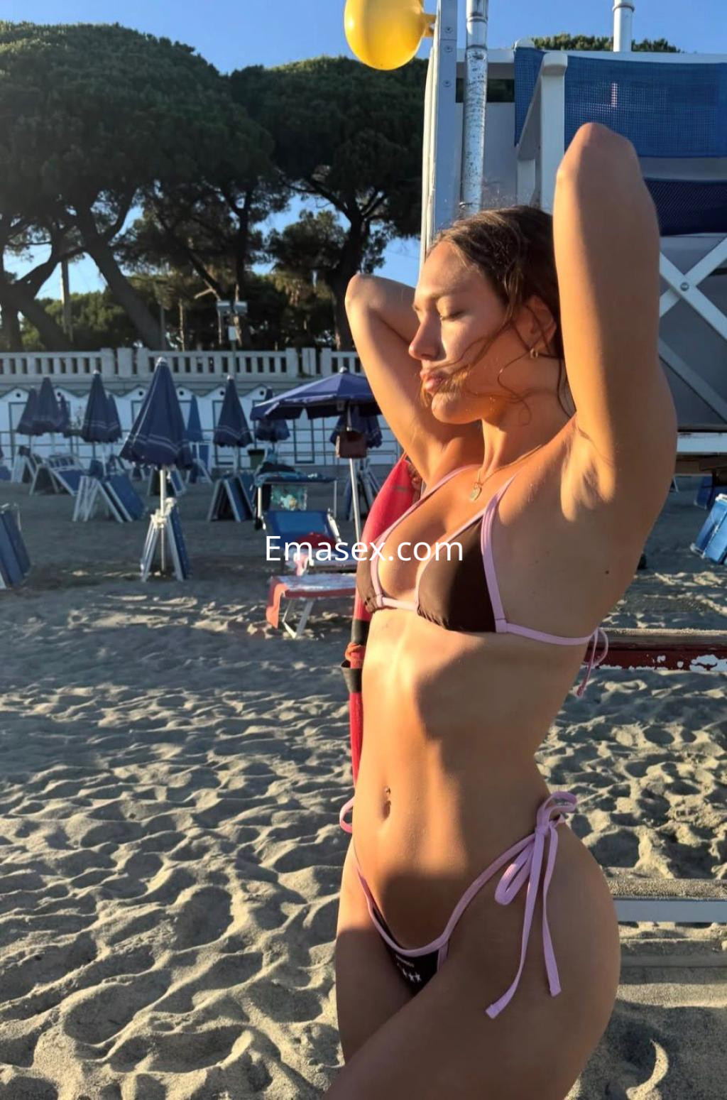 La puta se muestra en la playa de Málaga, luciendo un bikini negro con detalles rosas y disfrutando del sol.