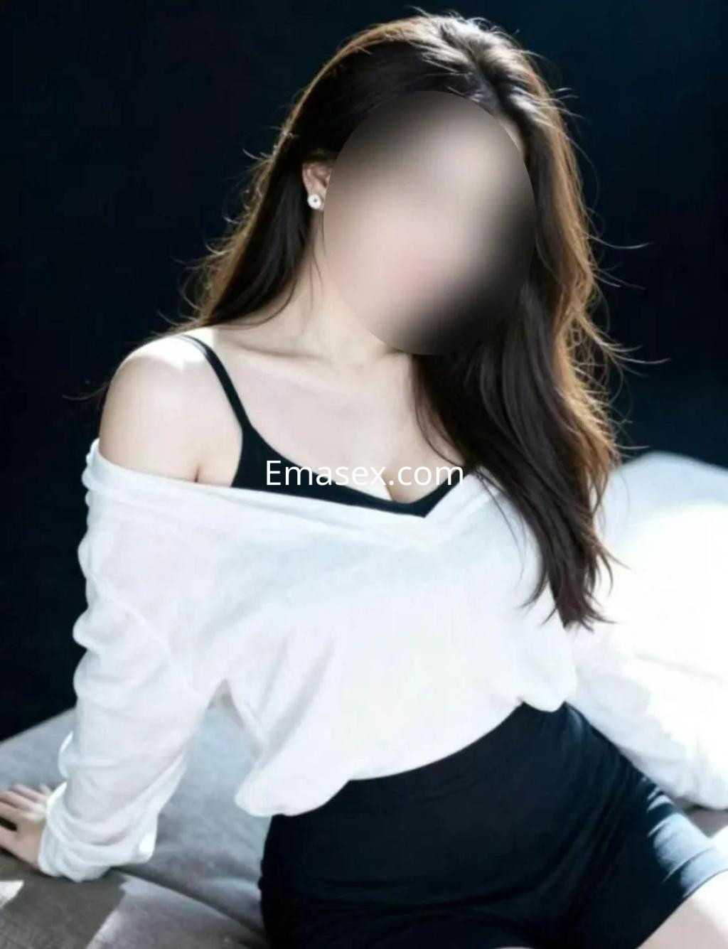 Escort en Alicante con cabello largo y suelto, vestida con blusa blanca y falda negra, posando de lado.