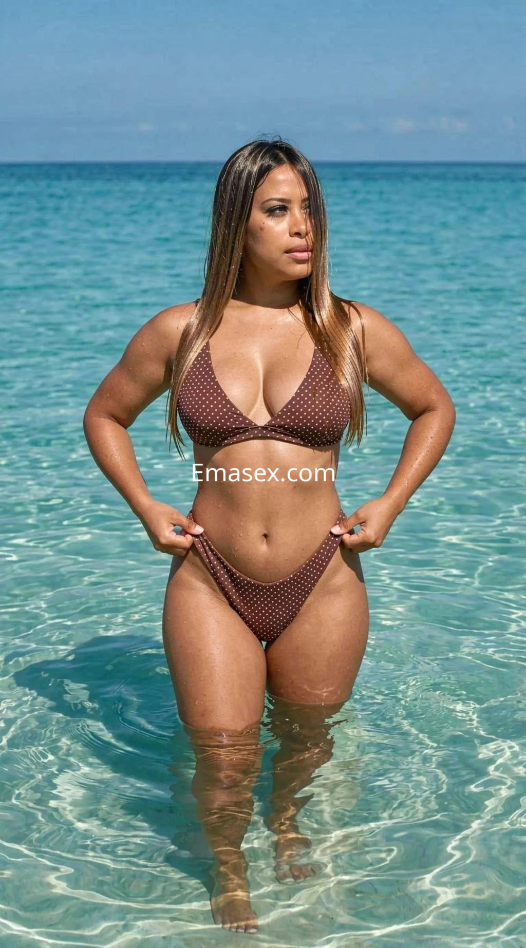 Puta de cabello largo y lacio en bikini marrón, posando en el agua clara de Palma de Mallorca.