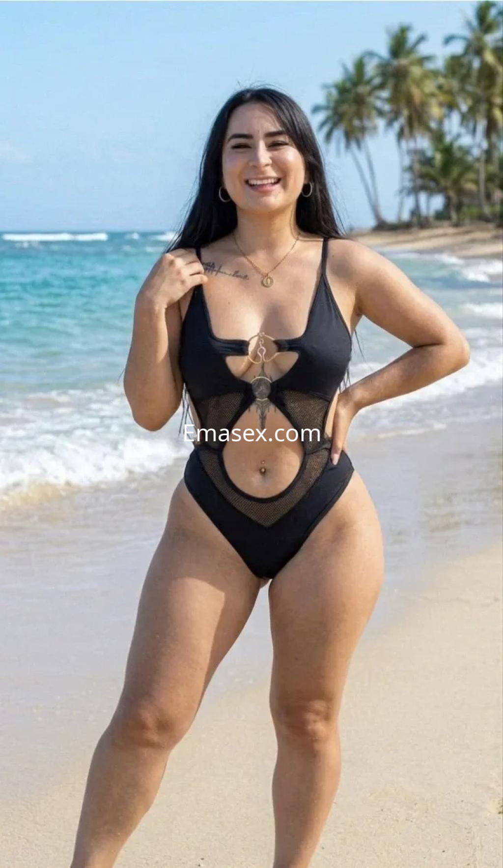 Escort en Burgos con cabello largo y oscuro, usando un bikini negro, sonríe mientras posa en la playa.