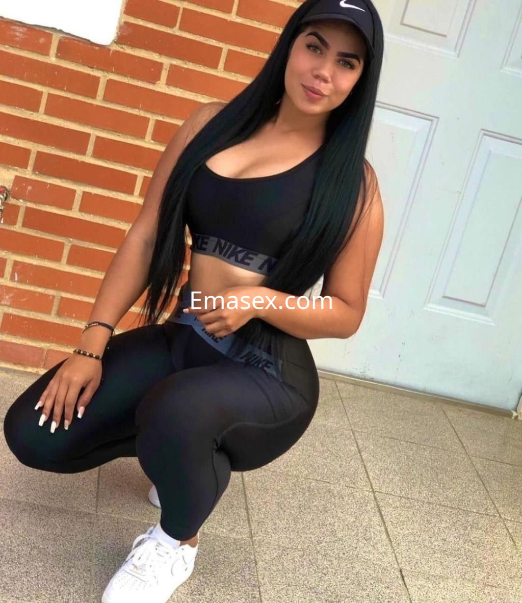 La puta viste un conjunto deportivo negro de Nike y se encuentra en una pose de cuclillas en Granada.