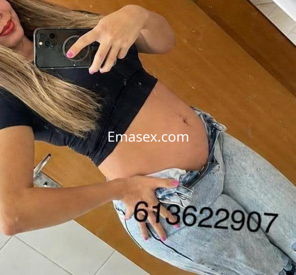 Puta con blusa negra y jeans ajustados, posando frente al espejo en un baño de Pontevedra.