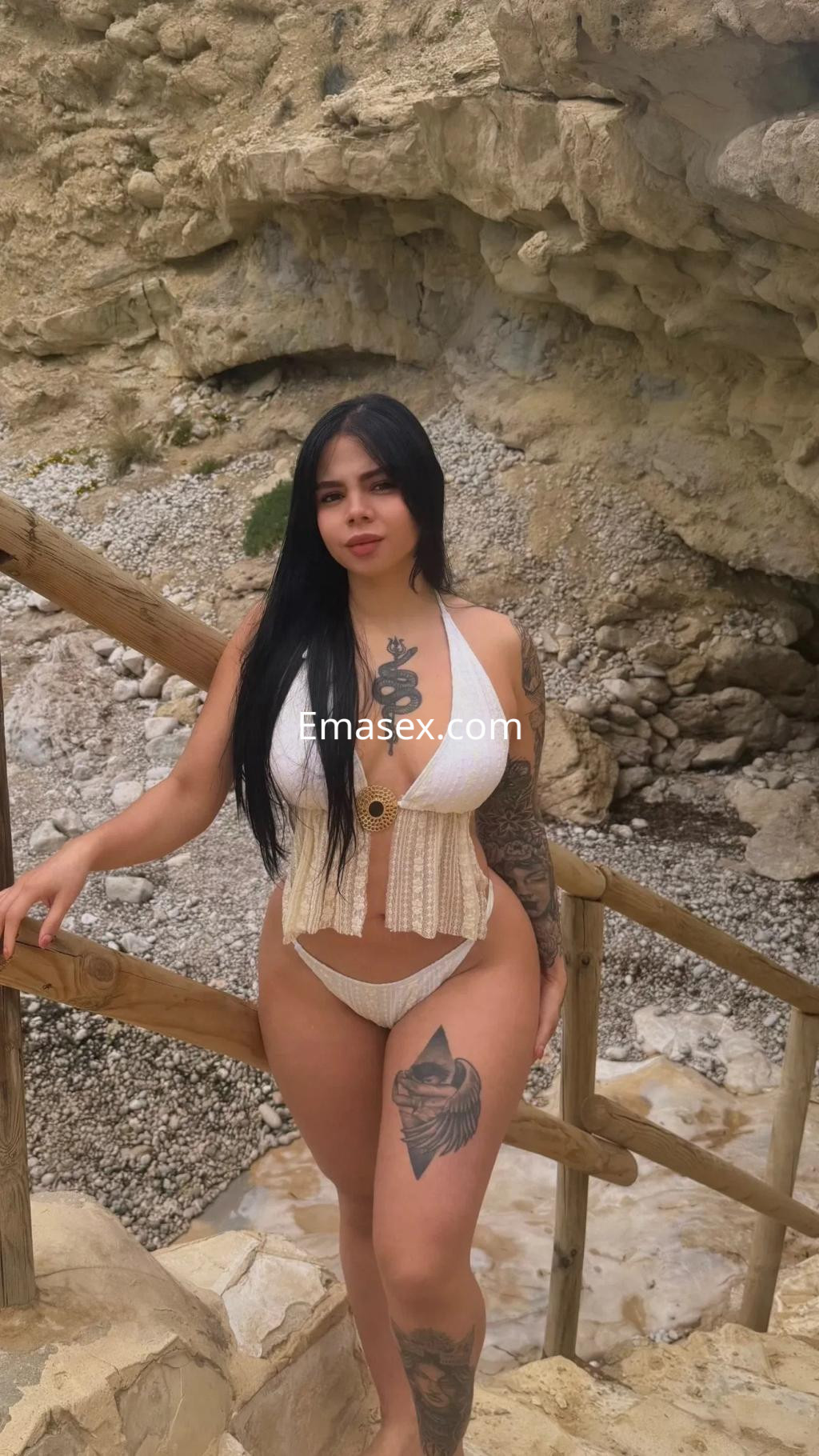 Puta en Alicante, con cabello largo y oscuro, luciendo un bikini blanco mientras posa en un entorno natural.