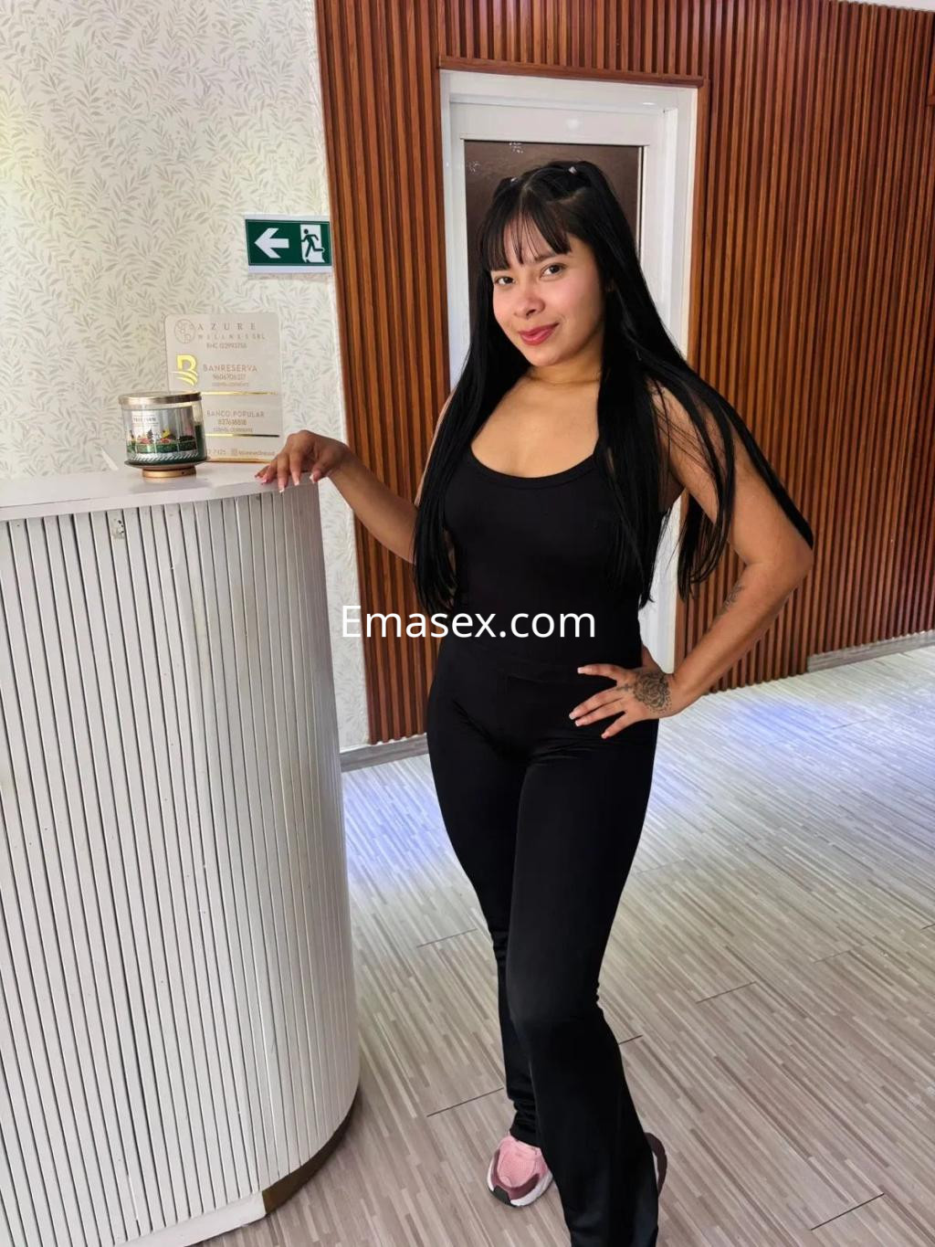 Puta de piel clara y cabello largo, viste un conjunto negro mientras posa en un entorno elegante en Oviedo.