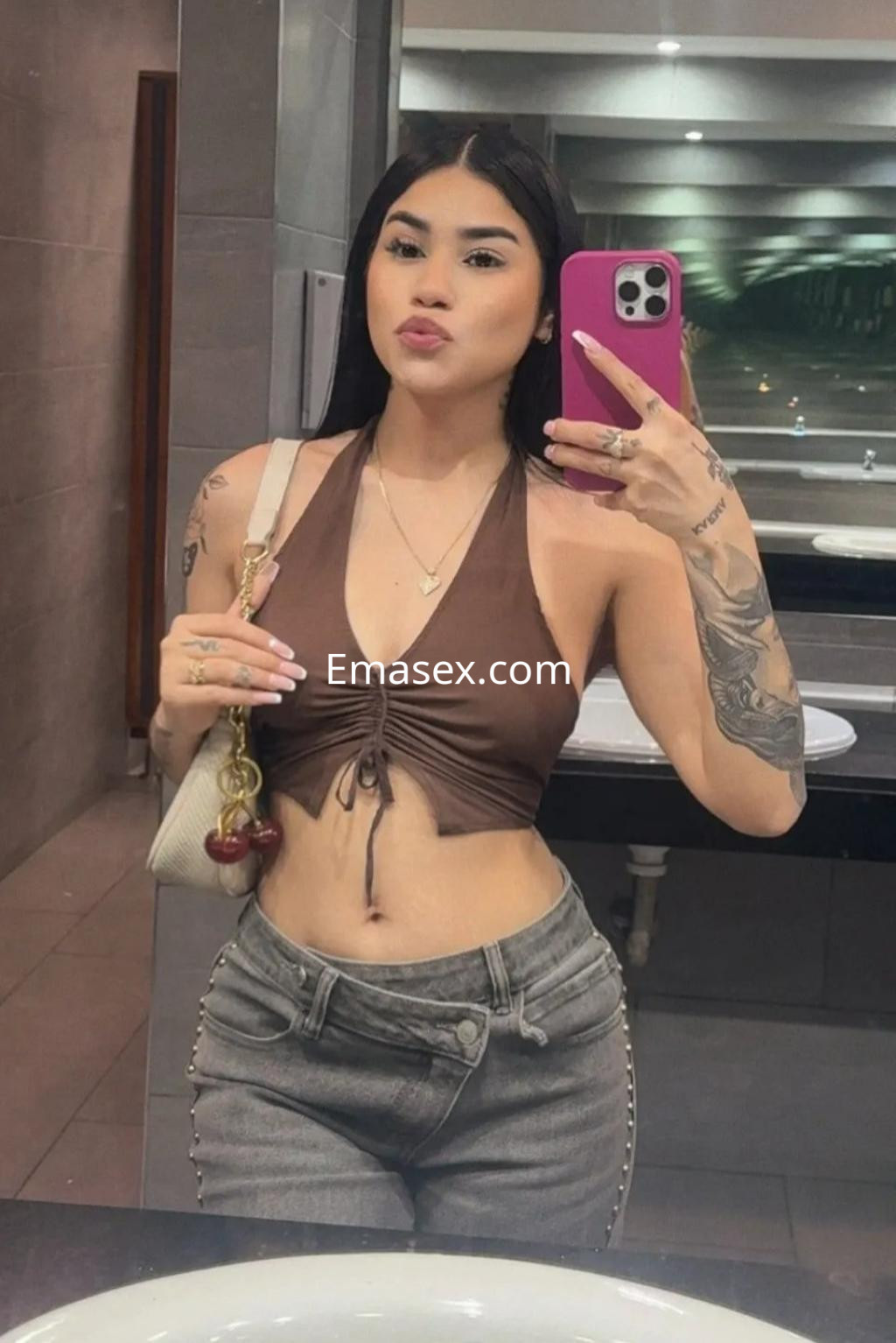 Puta en Madrid, posando en un espejo con top marrón y jeans ajustados, mostrando su estilo moderno.