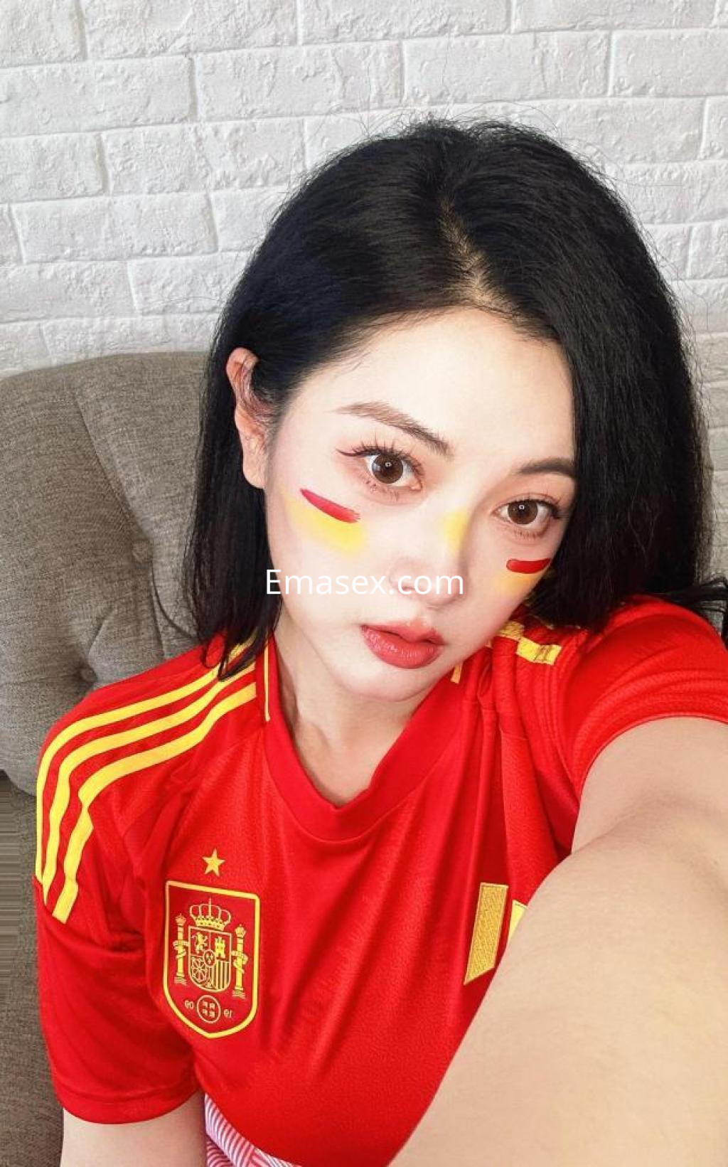 Escort en Granada luciendo una camiseta roja de la selección española con detalles en los colores de la bandera.