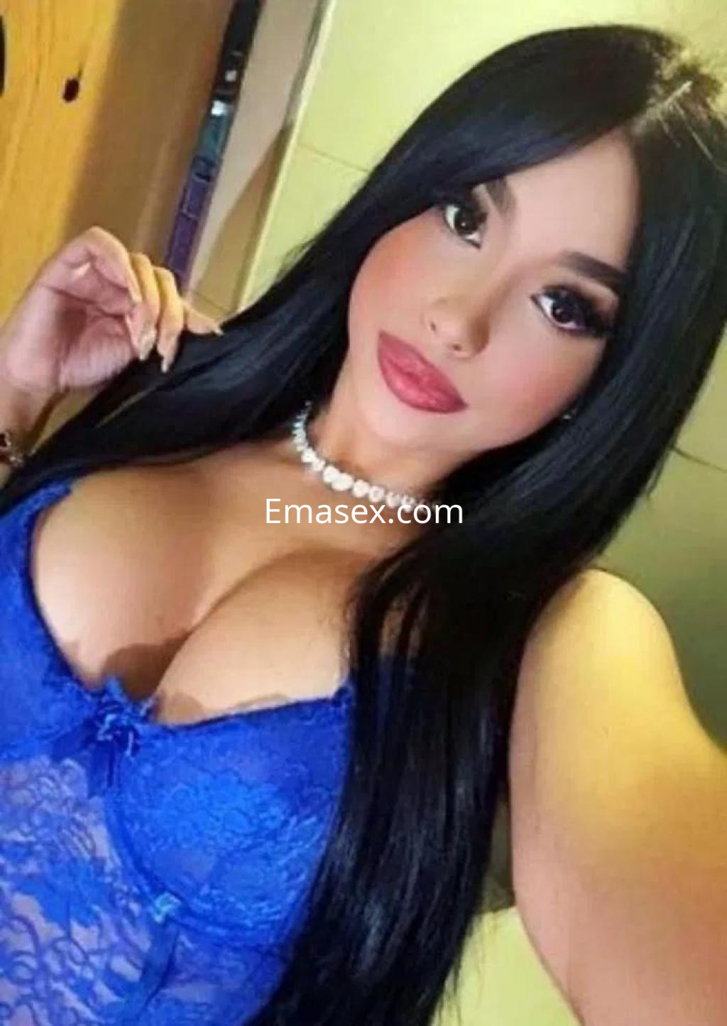 Escort en Madrid con cabello largo y lacio, vistiendo un conjunto de lencería azul y collar delicado.