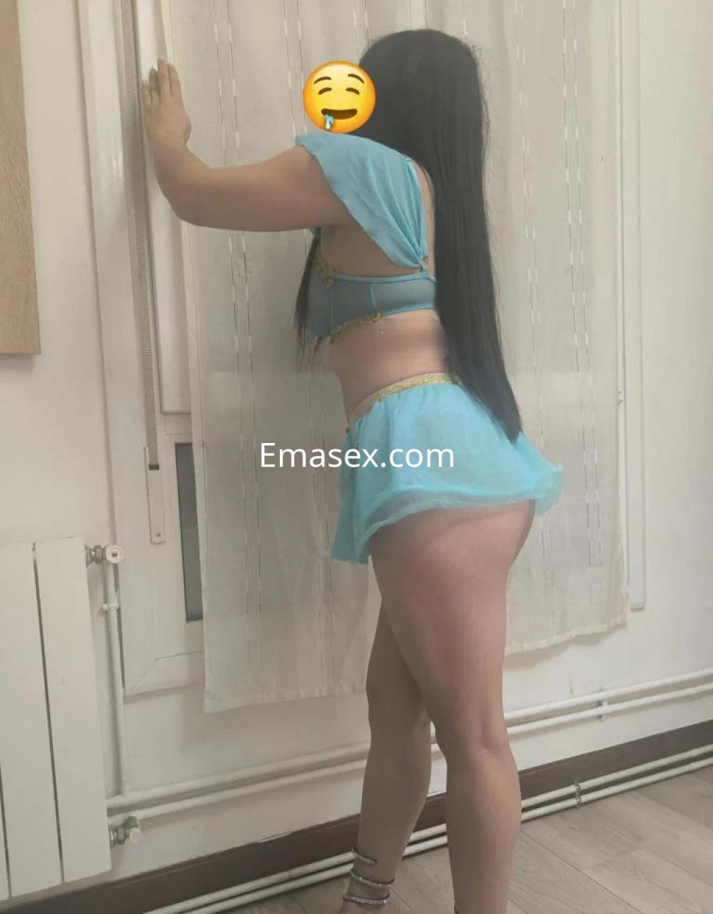 Escort en Bilbao con cabello largo y lacio, vistiendo un conjunto azul claro que destaca su figura.