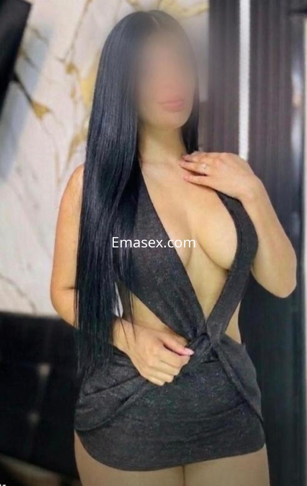 Puta con cabello largo y lacio, viste un vestido ajustado de color oscuro que resalta su figura en Salamanca.