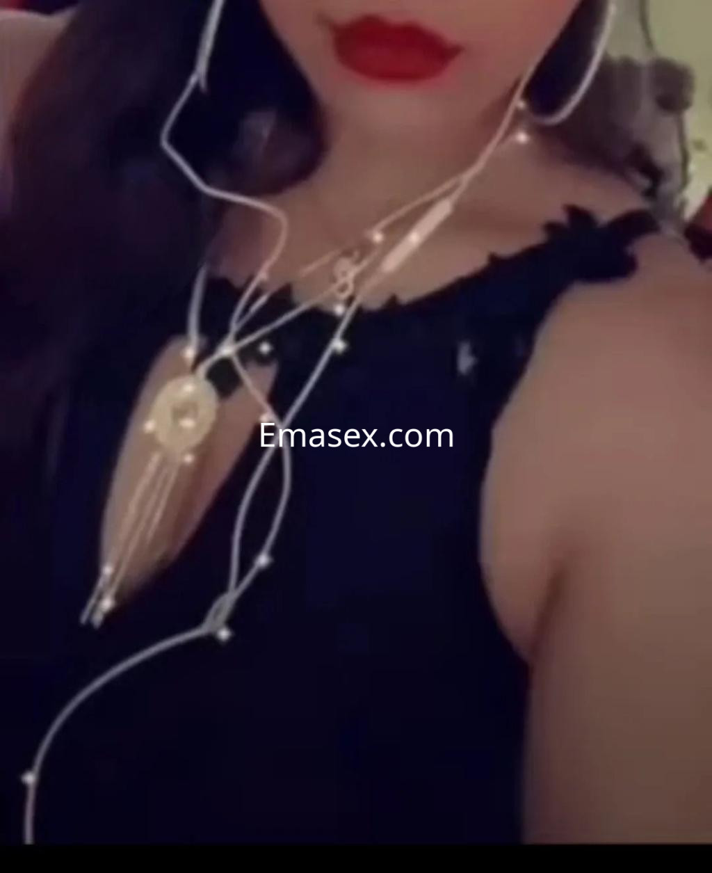 Escort en Madrid con cabello largo y oscuro, luciendo un top negro con detalles de encaje y accesorios elegantes.