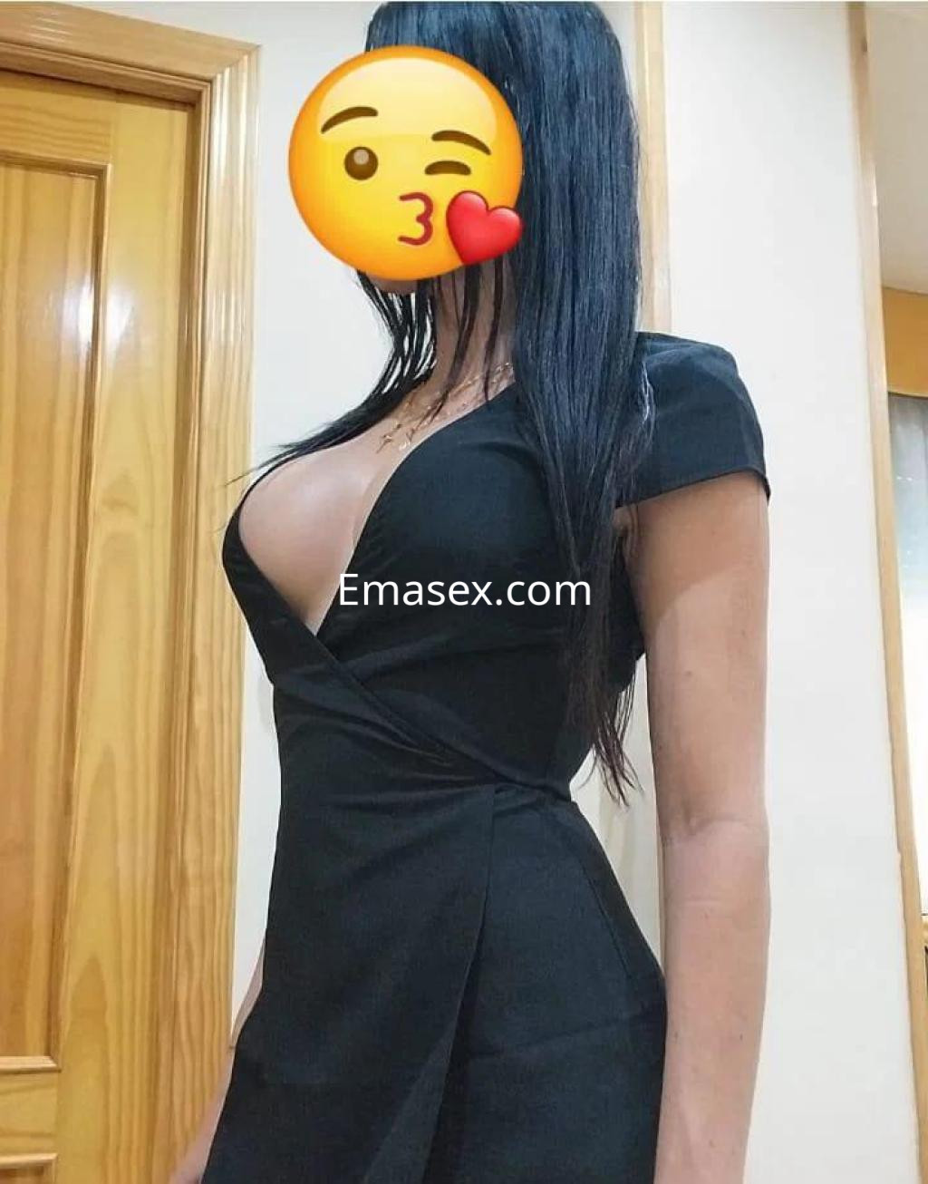 Escort en Toledo, con un vestido negro ajustado que destaca su figura y cabello largo y lacio.