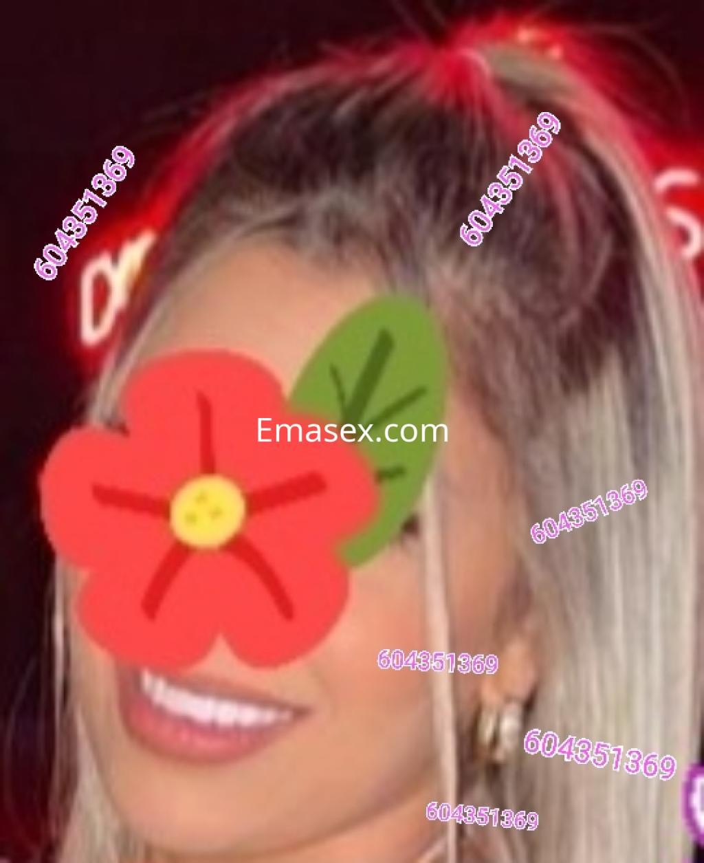 Escort con cabello rubio y lacio, sonriente, en un ambiente iluminado con luces de neón en León.
