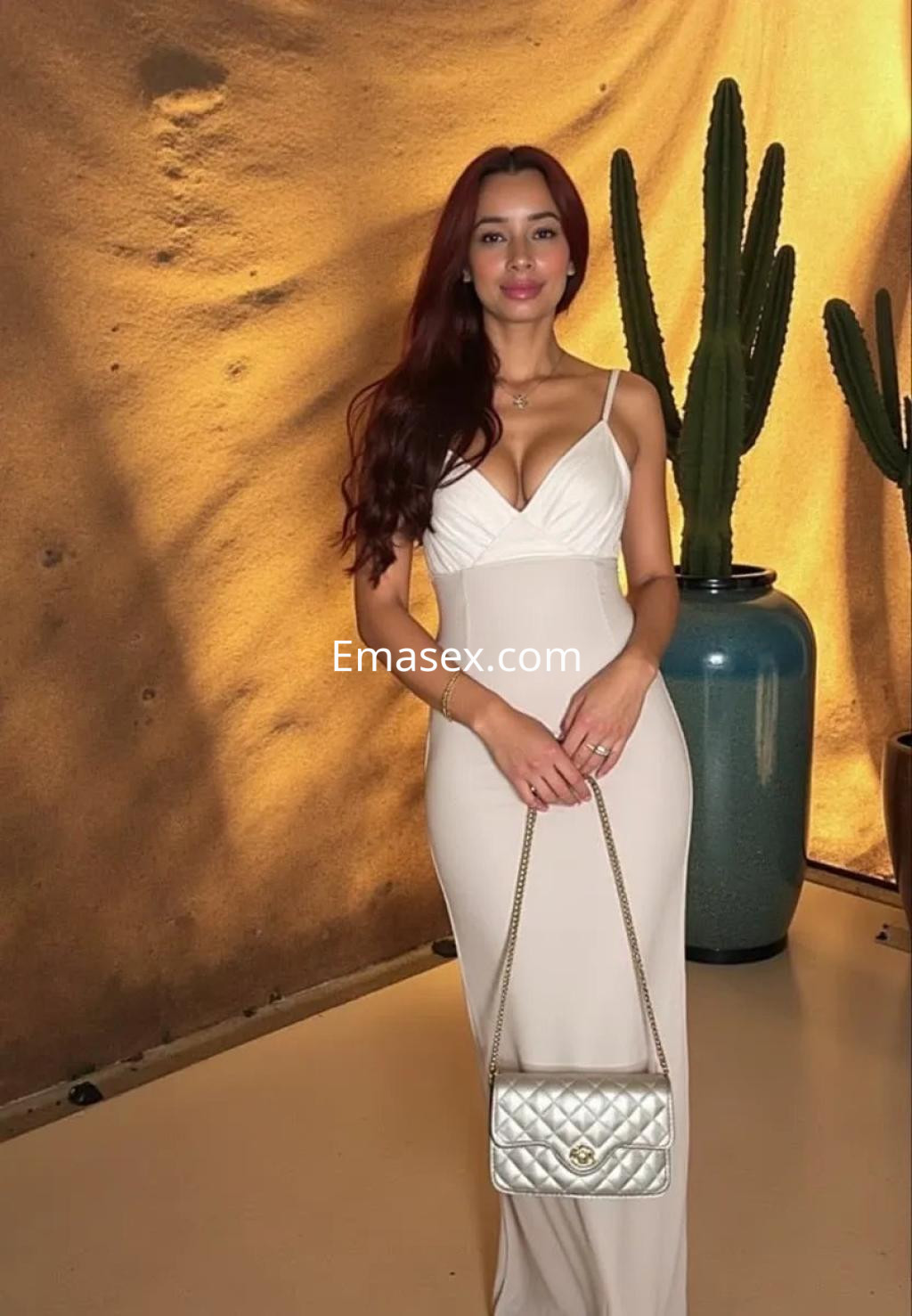 Escort en Palma de Mallorca con vestido ajustado blanco y cabello largo, posando frente a un fondo decorativo.
