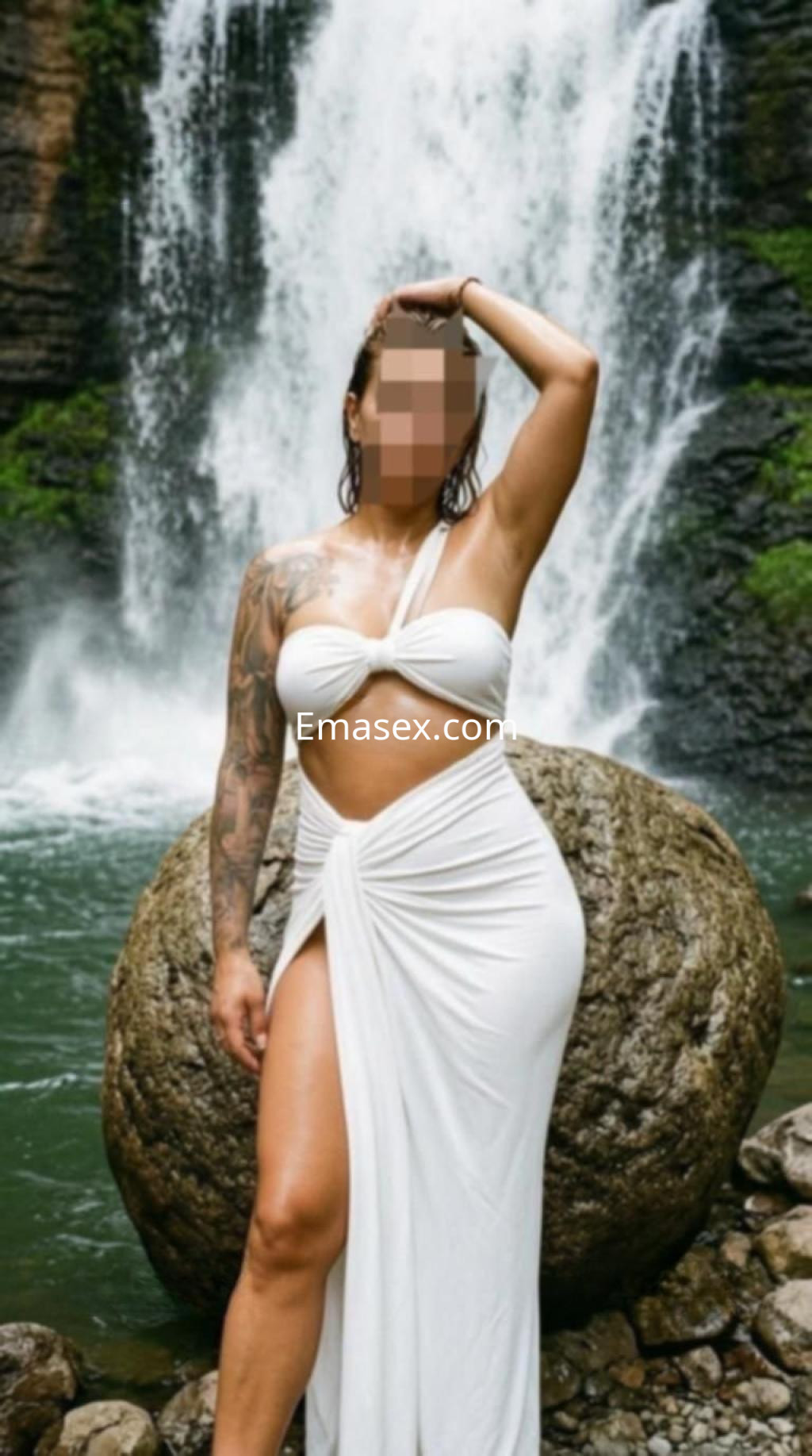 Puta posando con un vestido blanco ajustado junto a una cascada en Toledo, luciendo un tatuaje en el brazo.