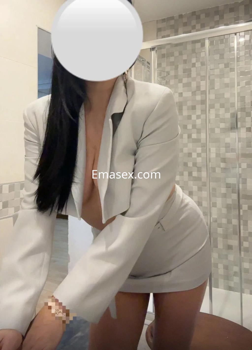 Puta en Valladolid viste un conjunto blanco con chaqueta y falda corta, destacando su figura en un ambiente moderno.
