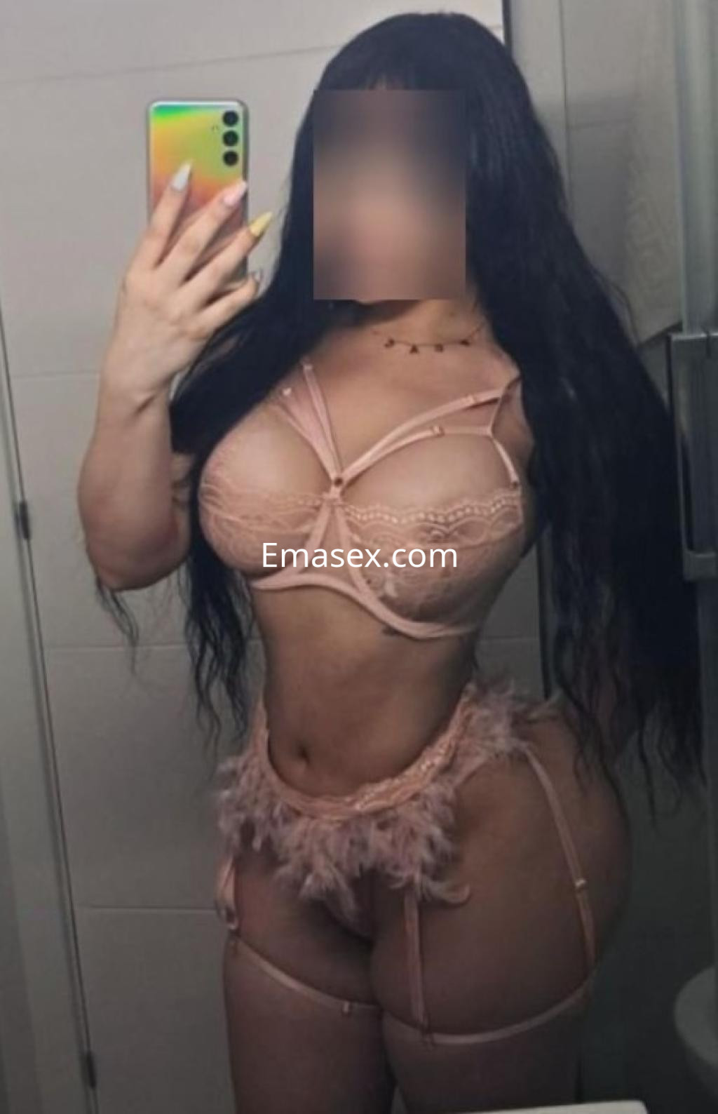 La puta posa en un baño con lencería rosa, destacando su figura curvilínea y cabello largo.
