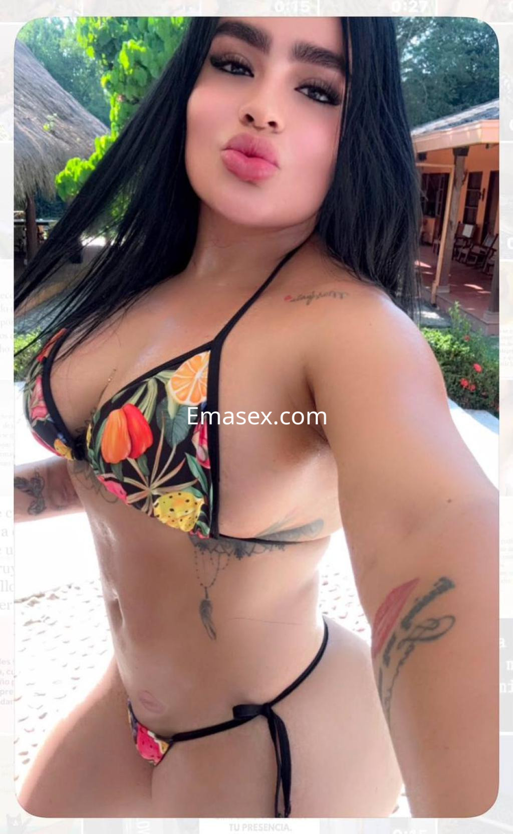 Escort en Donosti con cabello largo y lacio, luciendo un bikini colorido y posando con labios pintados.