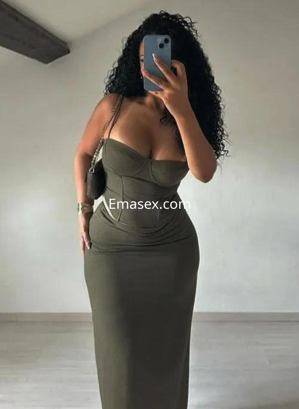 Escort en Las Palmas con vestido ajustado de color verde oliva, mostrando curvas y cabello rizado.