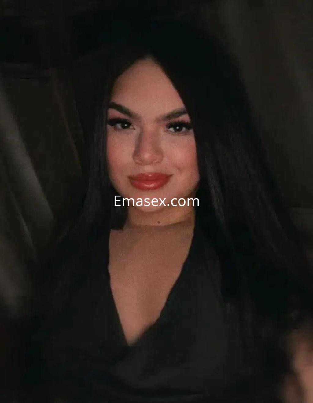 La puta en Alicante luce una blusa oscura, con cabello largo y lacio, posando con una sonrisa.