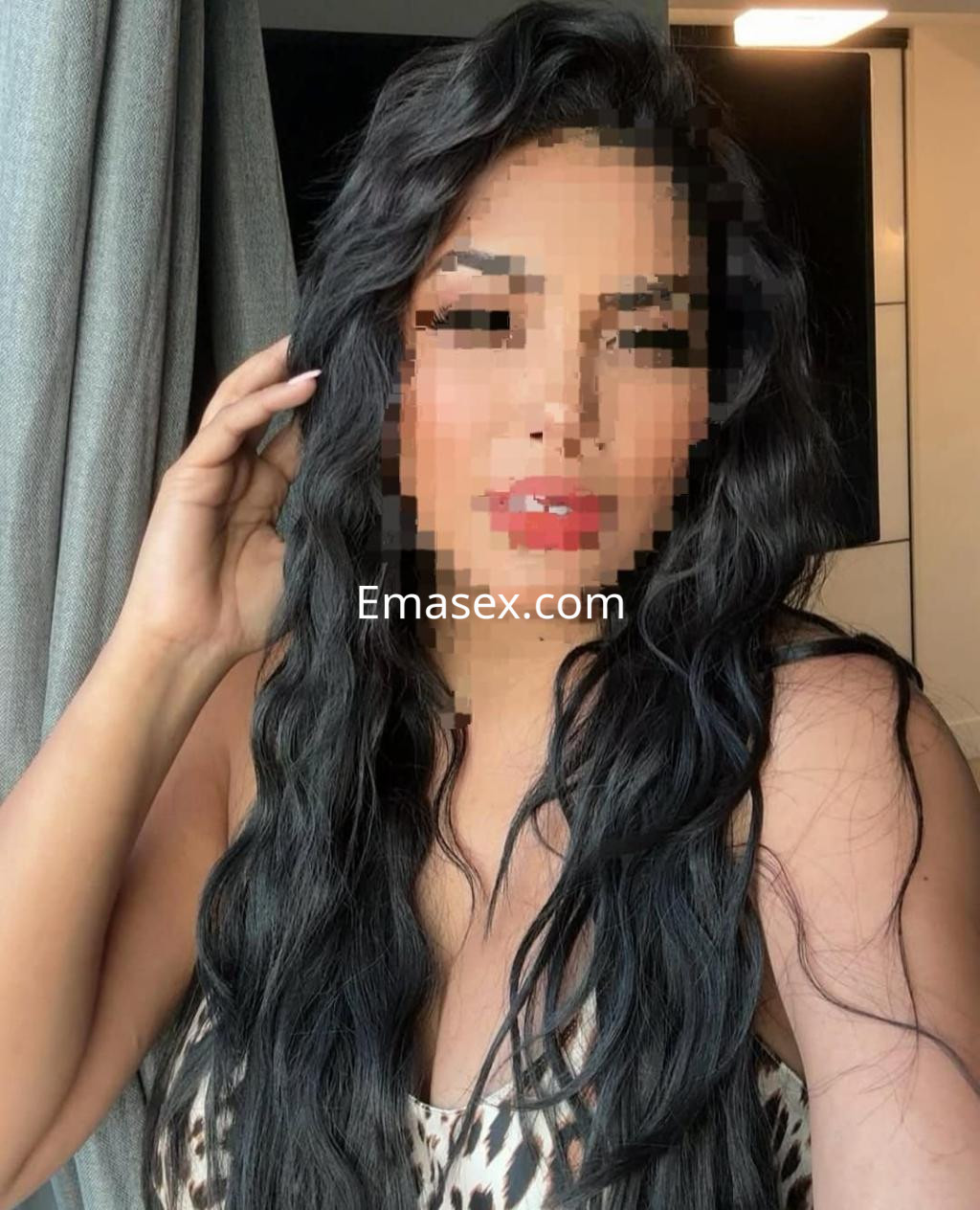 La puta luce un vestido de leopardo, con cabello largo y ondulado, posando en un entorno moderno en Córdoba.
