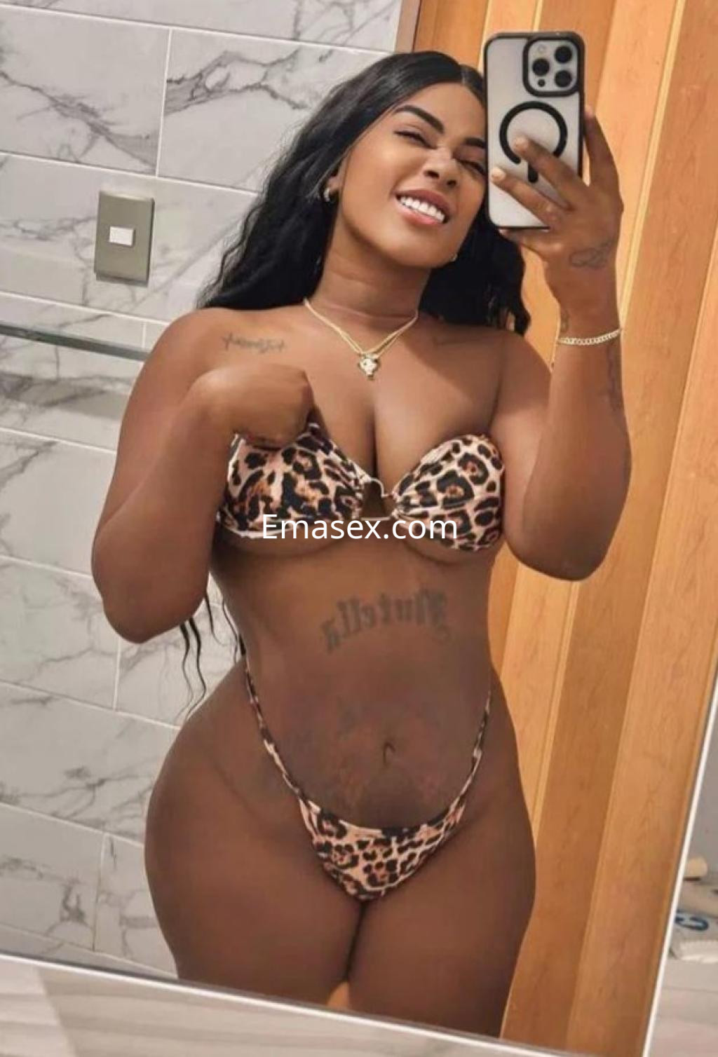 La puta sonríe mientras se toma una selfie en un baño, luciendo un bikini de leopardo en Almería.
