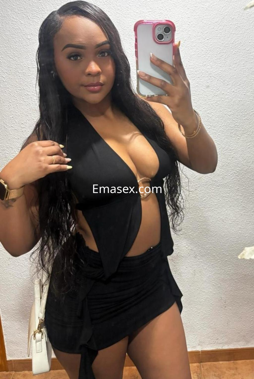 Puta en Lleida luciendo un top negro con escote y una falda corta, con cabello largo y lacio.