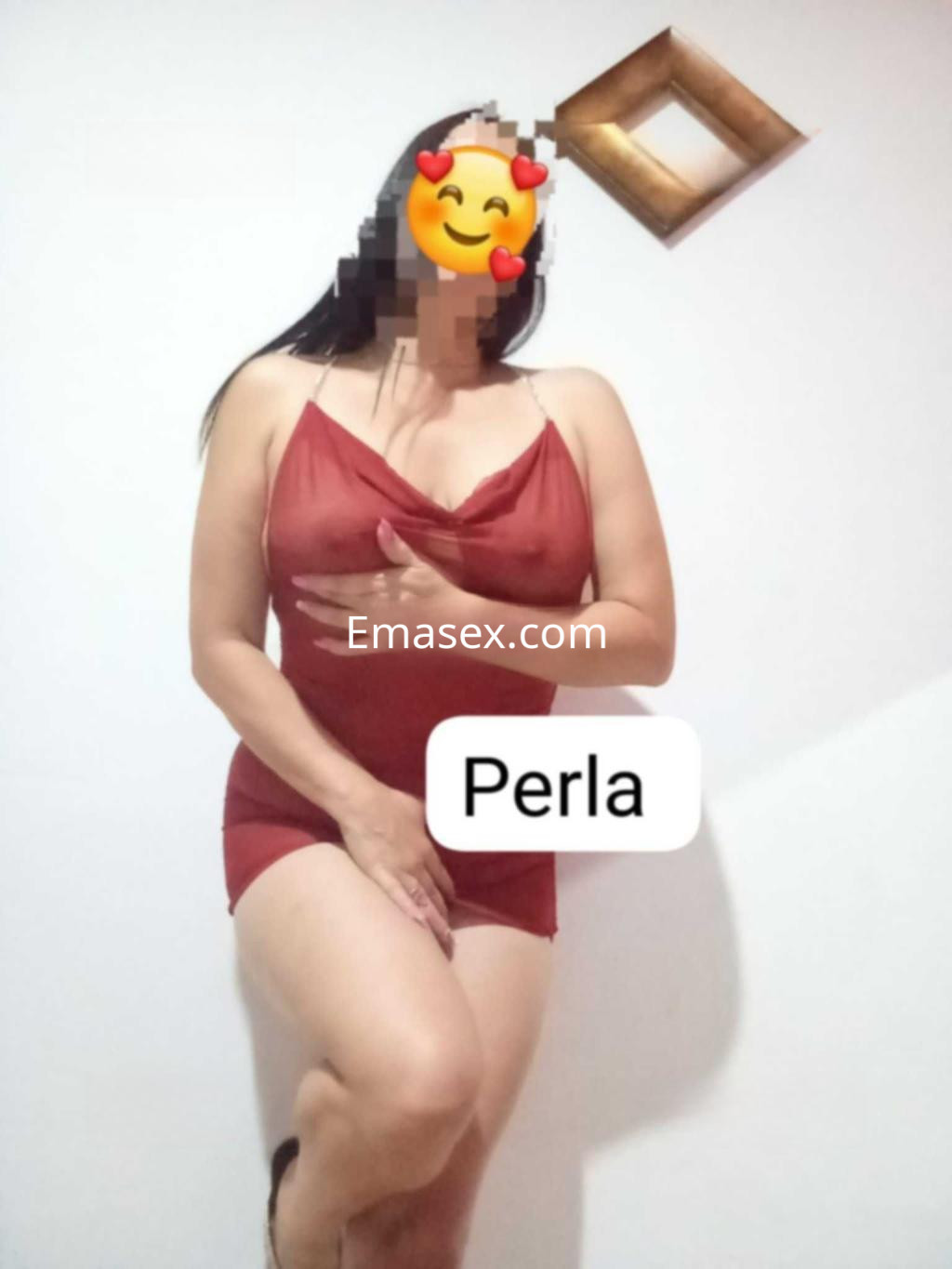 Puta en Huelva, con lencería roja, pose seductora y fondo neutro, mostrando confianza y sensualidad.