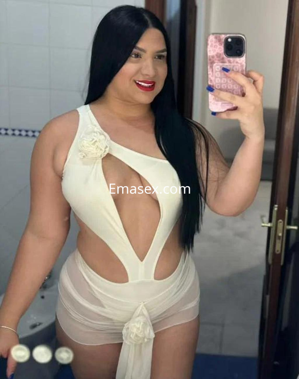La puta luce un bañador blanco con cortes en la zona del pecho, sonriendo mientras se toma un selfie en Sevilla.