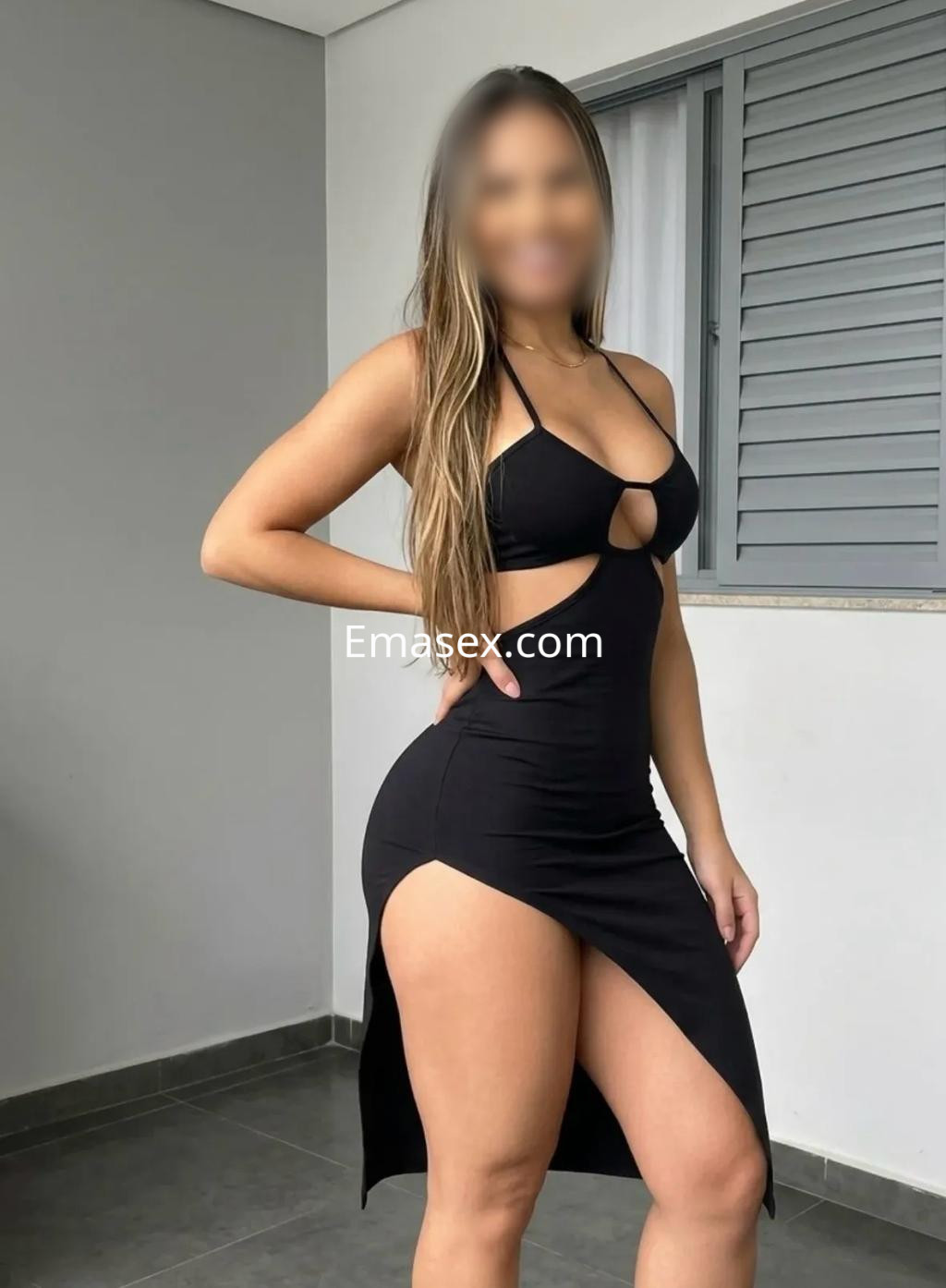 Puta en Valladolid luciendo un vestido negro ajustado con cortes laterales, de cabello largo y lacio.