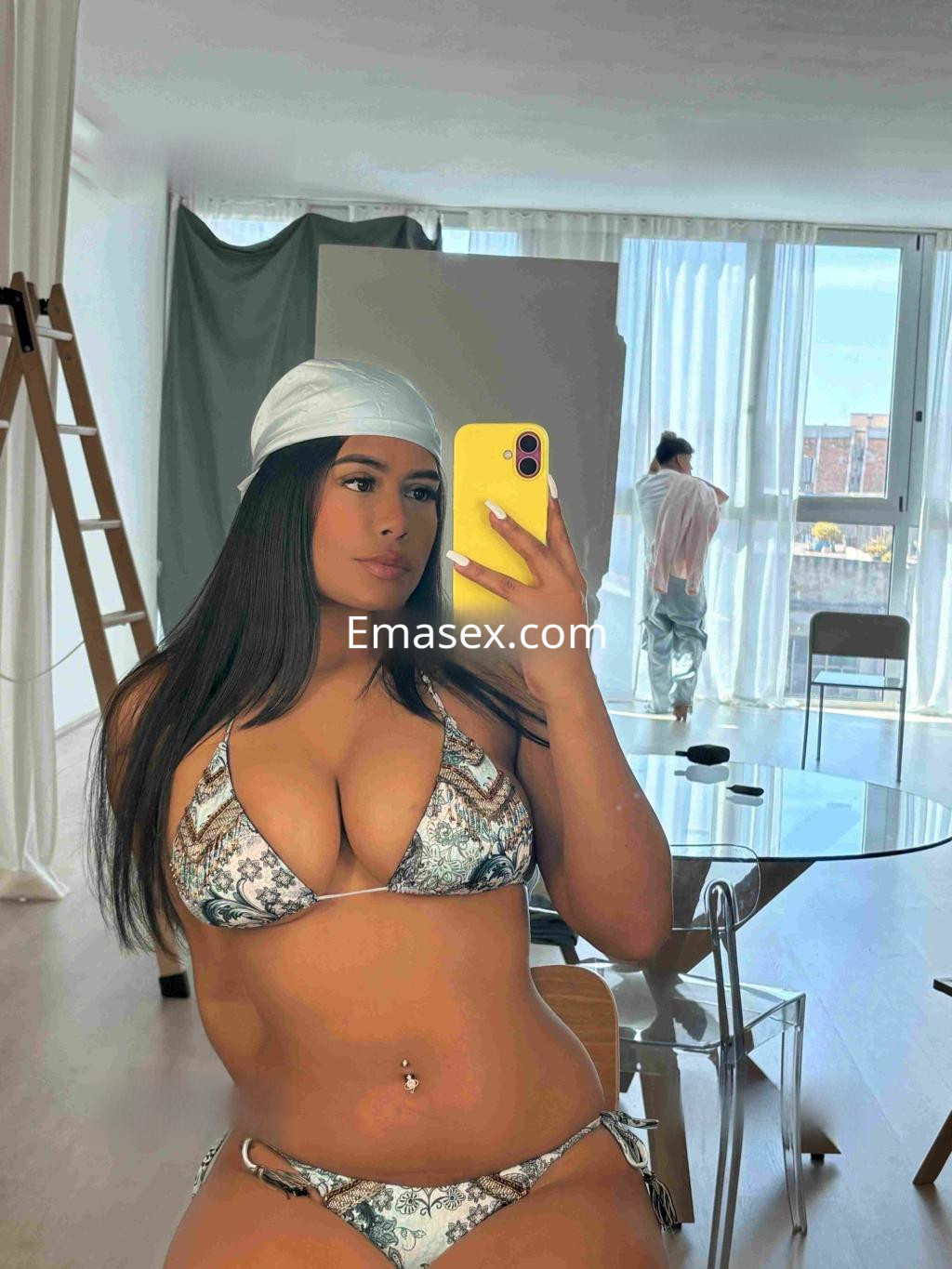 Puta posando en un espejo con bikini de estampado, en un luminoso apartamento de Barcelona.