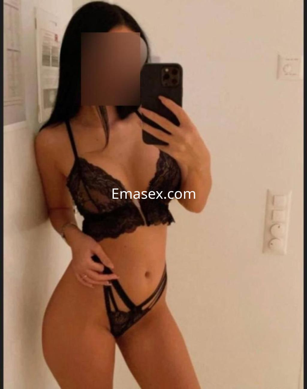 Puta en Murcia posando en lencería negra, mostrando su figura esbelta frente al espejo.