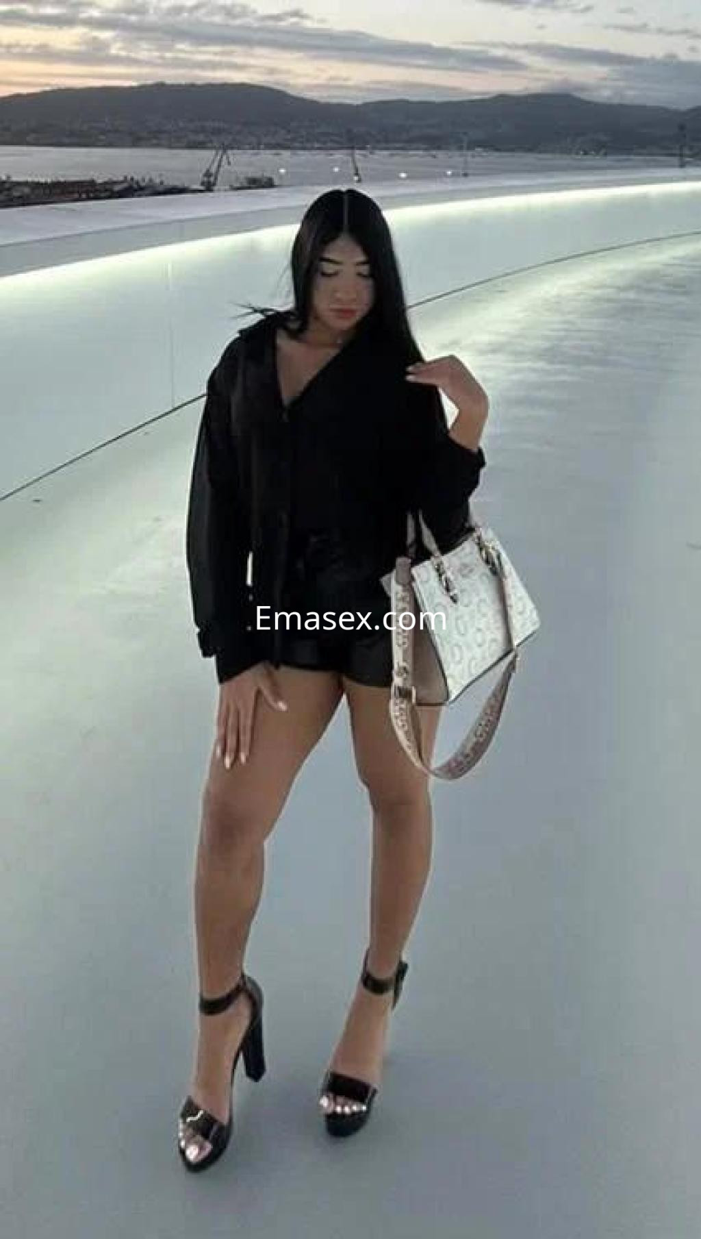 Puta de piel clara con cabello largo y lacio, vestida con una blusa negra y shorts en Valencia.