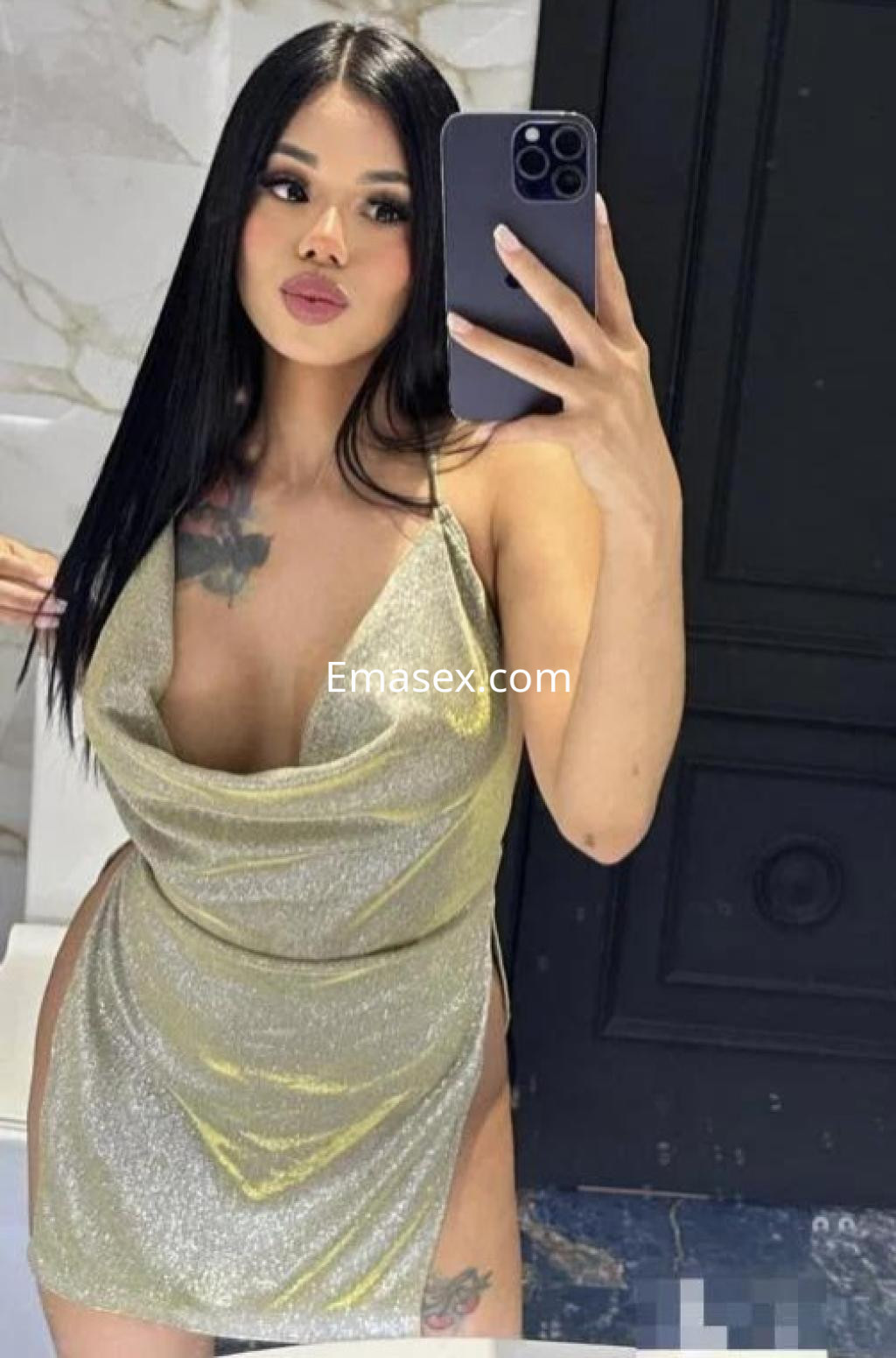 Escort en Granada con cabello largo y lacio, luciendo un vestido brillante y ajustado frente al espejo.