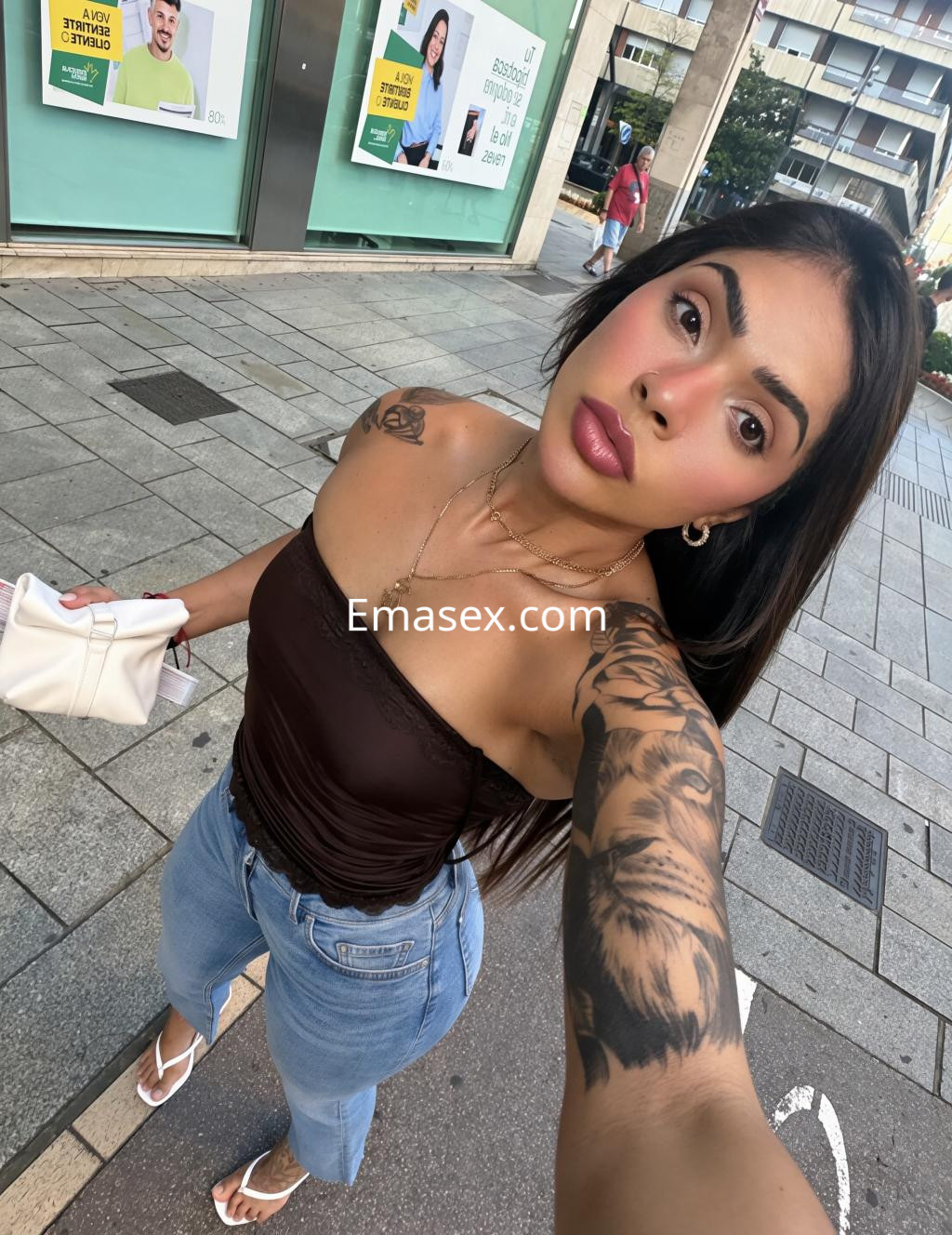 Escort en Logroño vistiendo un top marrón y jeans, posando con una mirada directa en la calle.