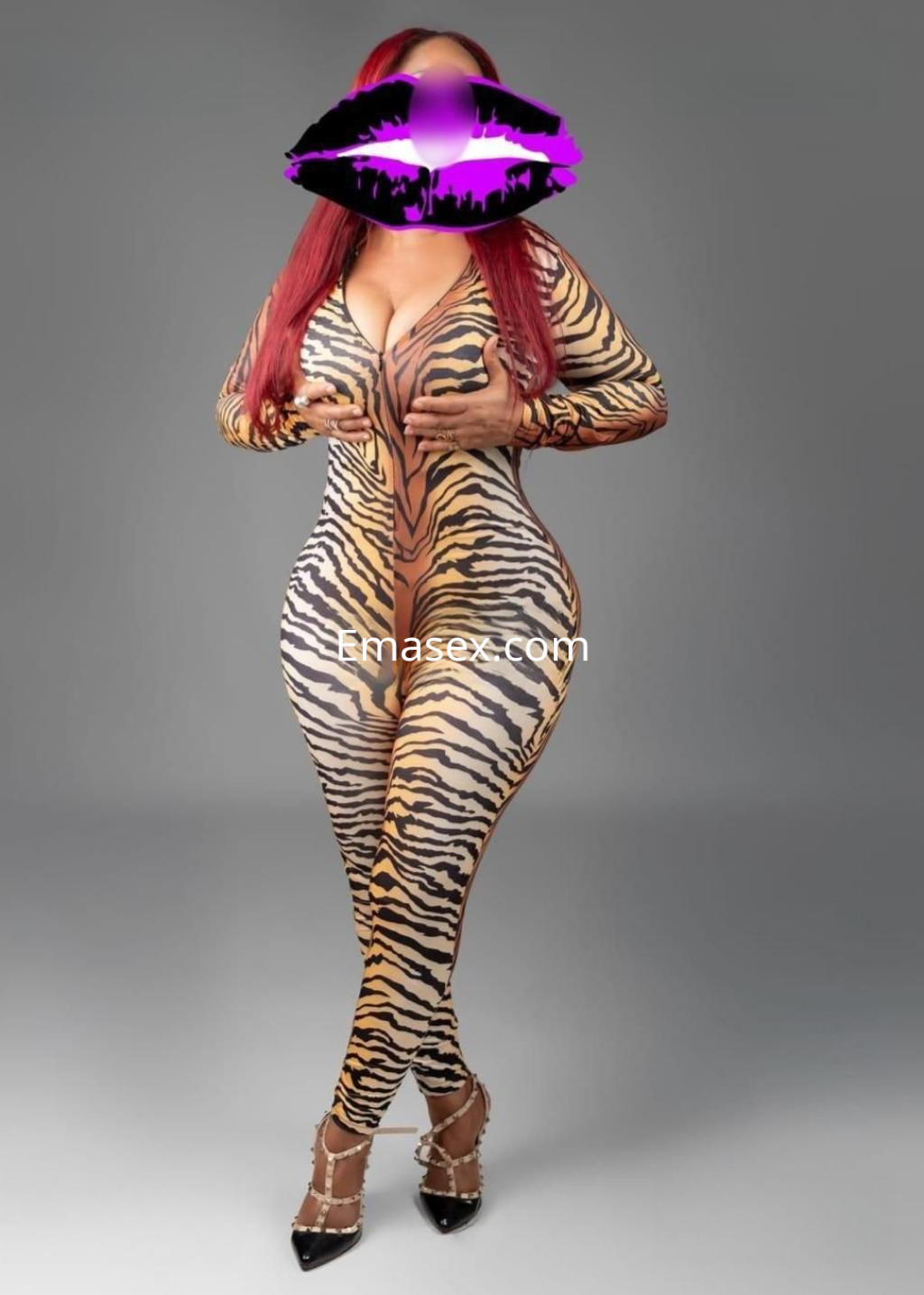 Escort en Tenerife vistiendo un ajustado body de estampado de tigre y tacones, posando con confianza.