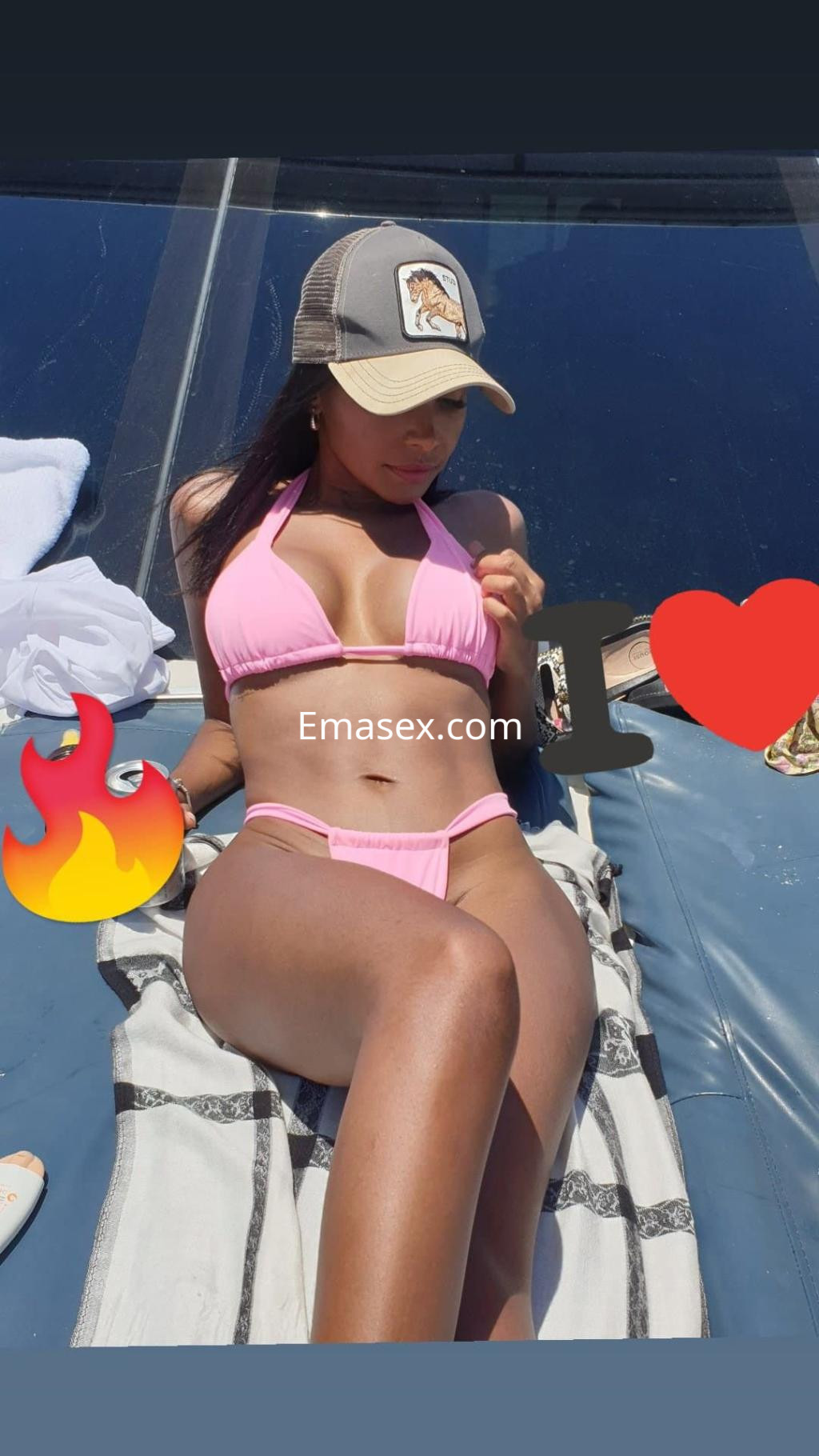 Puta en Palma de Mallorca, luciendo un bikini rosa mientras se relaja al sol sobre una toalla.
