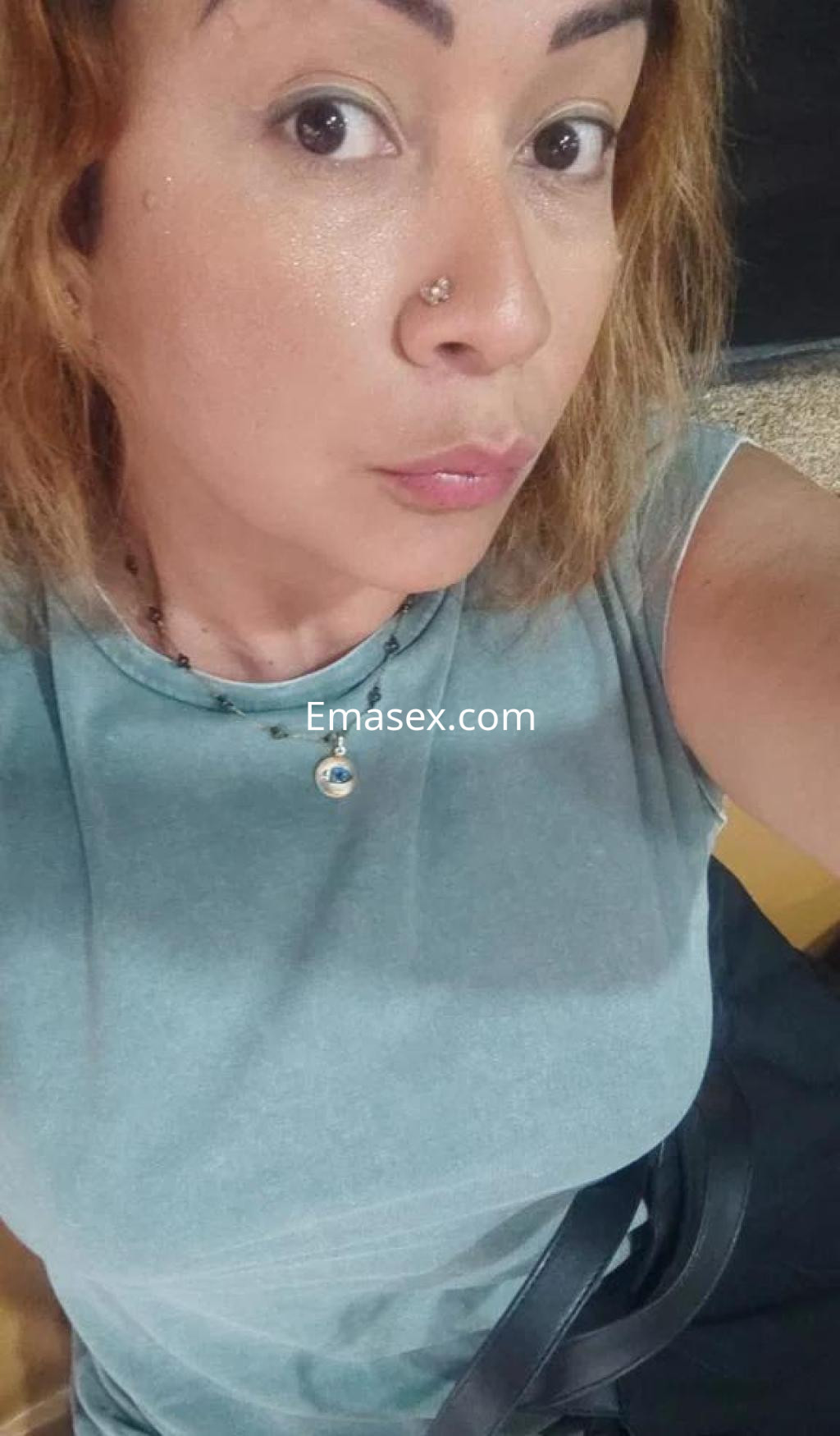 Escort en Lugo con cabello rizado y rubio, viste una camiseta azul clara y muestra un look natural y casual.