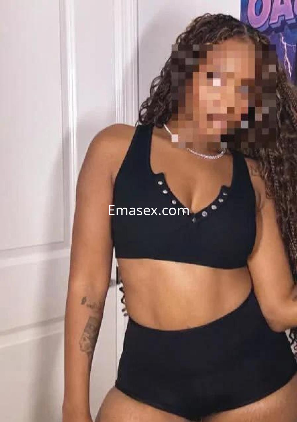Escort en Madrid con cabello rizado y oscuro, vistiendo un conjunto de lencería negra que resalta su figura.
