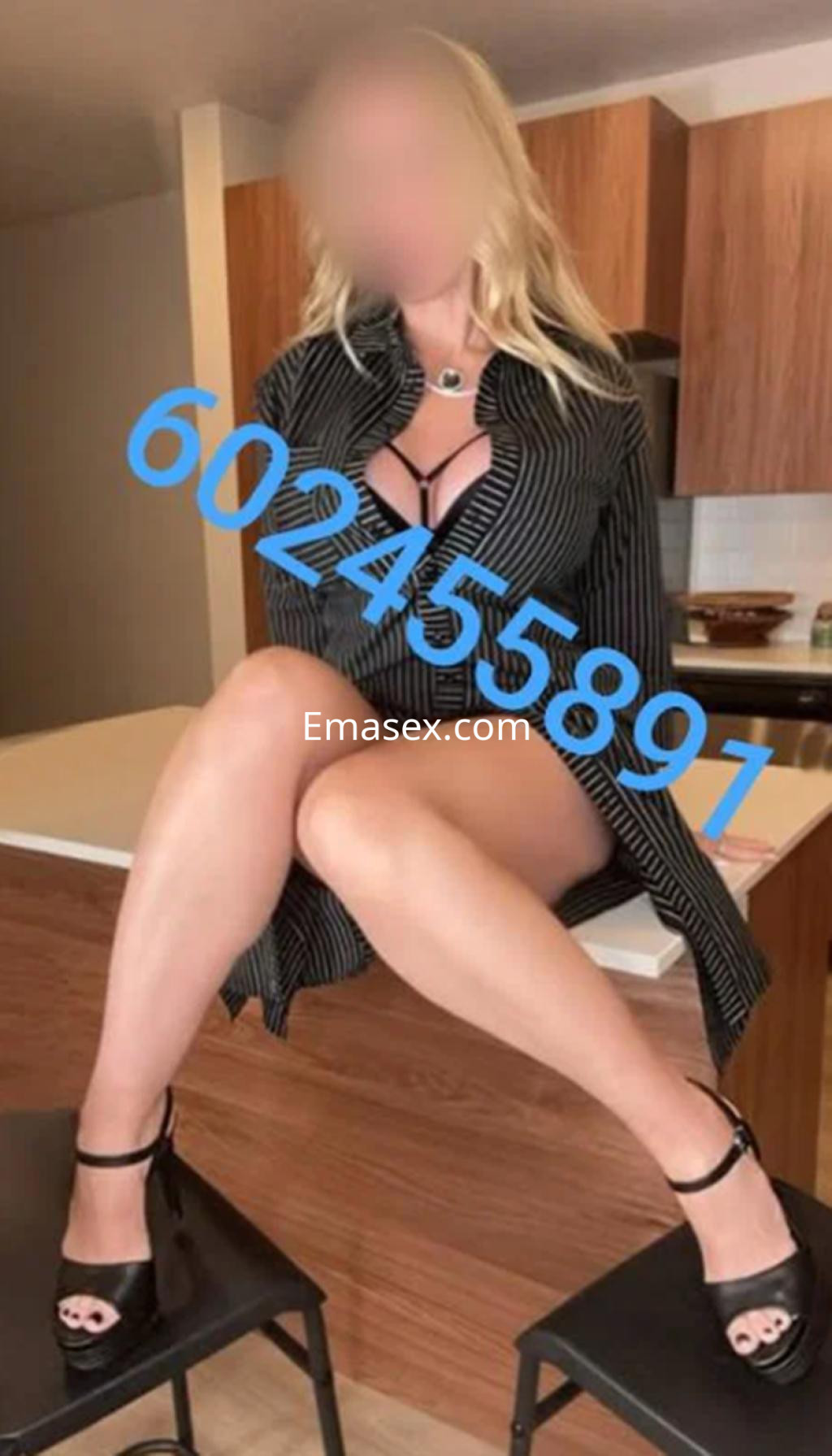 Escort en Logroño con blusa a rayas, tacones altos y piernas cruzadas, posando sobre una silla en un ambiente moderno.