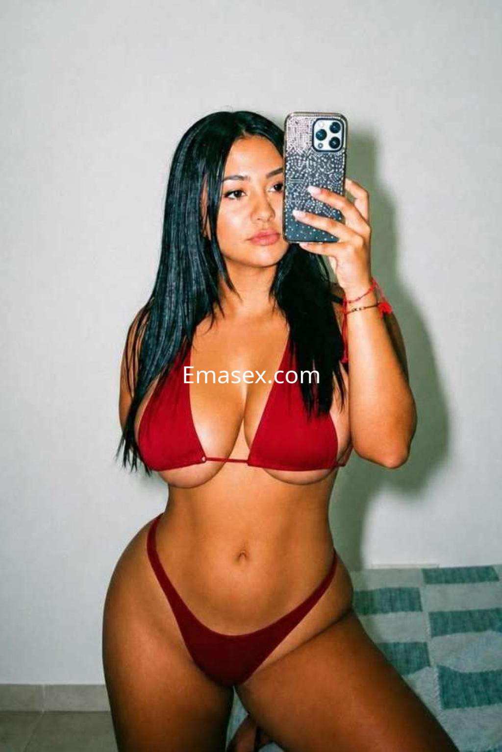 Puta con cabello largo y lacio, posa frente al espejo en bikini rojo, mostrando su figura en Ibiza.