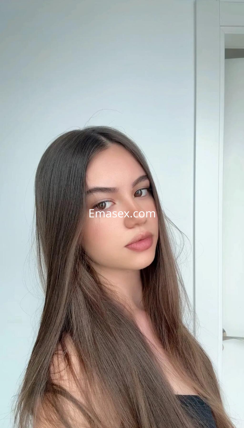 Puta con cabello largo y lacio, de piel clara, posa en un fondo neutro en Córdoba.