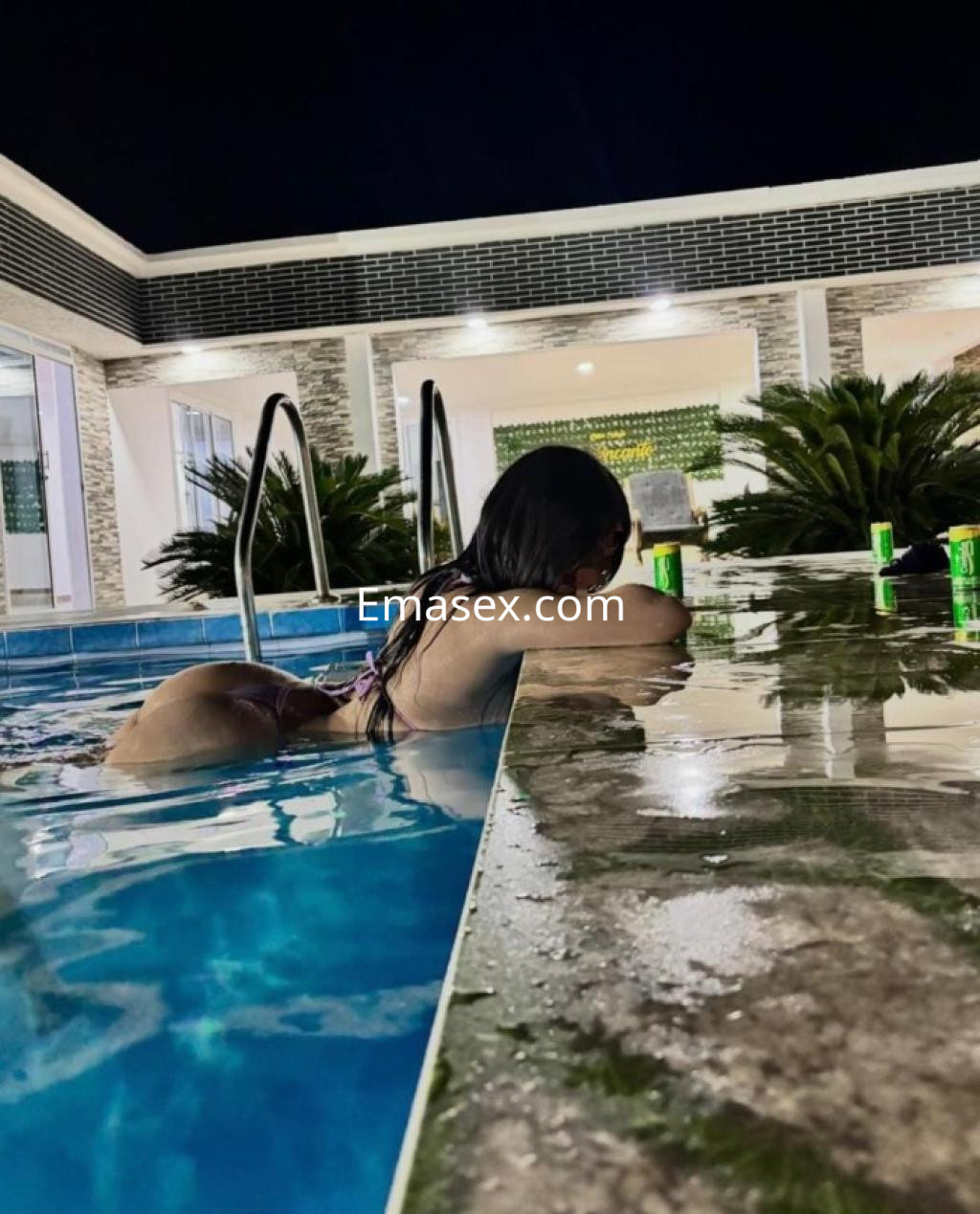 Escort en Santiago, recostada sobre el borde de una piscina, luciendo un bikini mientras se relaja.