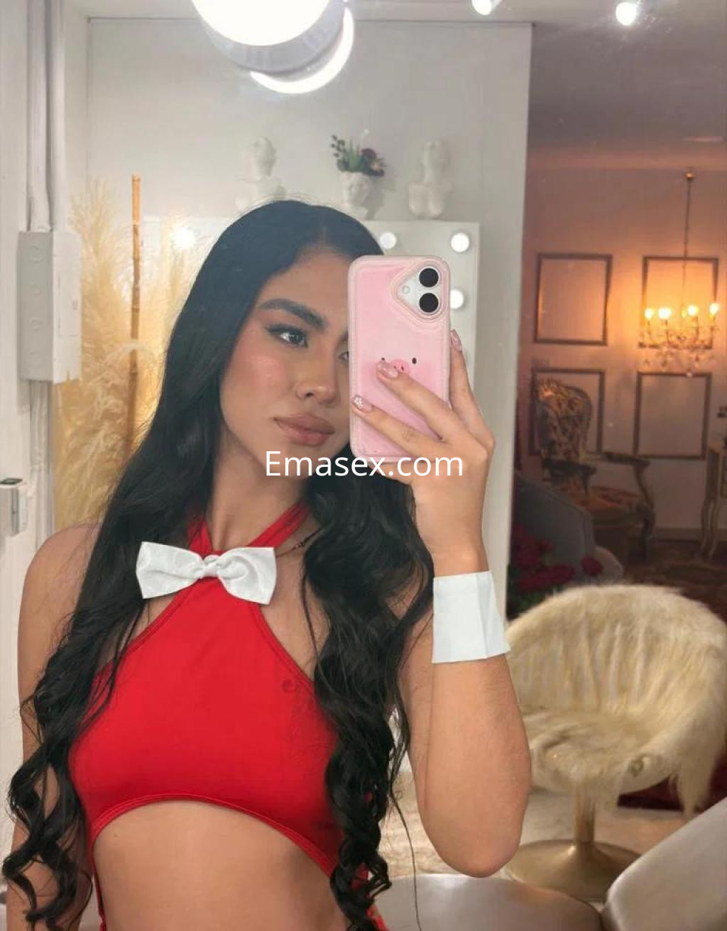Puta con cabello largo y lacio, vestida con un bikini rojo y detalles blancos, posando frente a un espejo en Madrid.