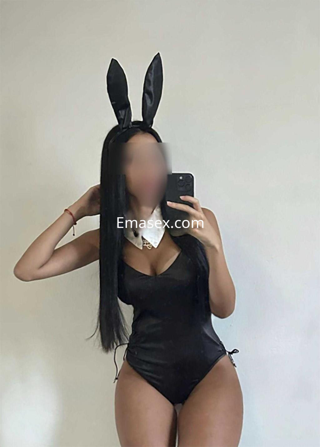 La puta posa con un traje de conejita negro y orejas, mostrando su figura en Tarragona.