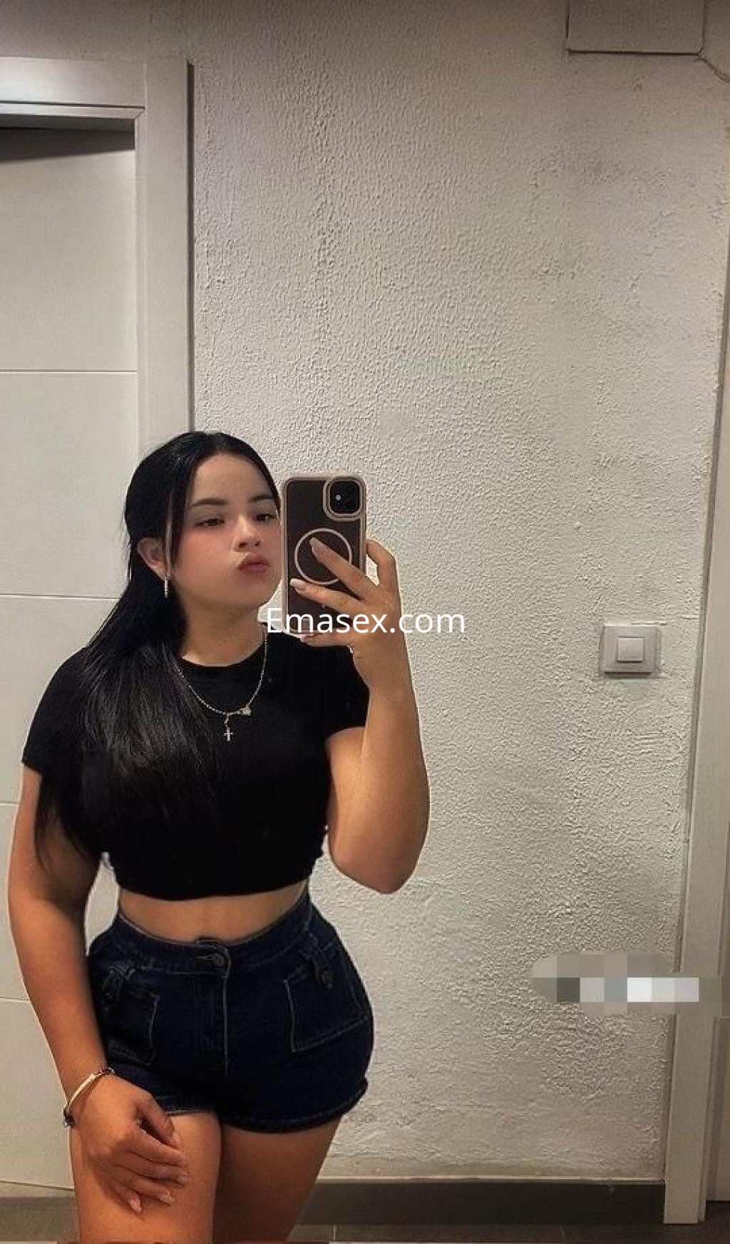 La puta luce un top negro y shorts de mezclilla mientras se toma una selfie en un baño en Toledo.